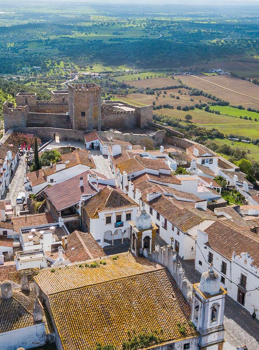 Vue aérienne du village historique de Monsaraz, dans l'Alentejo, mettant en valeur le château au sommet de la colline