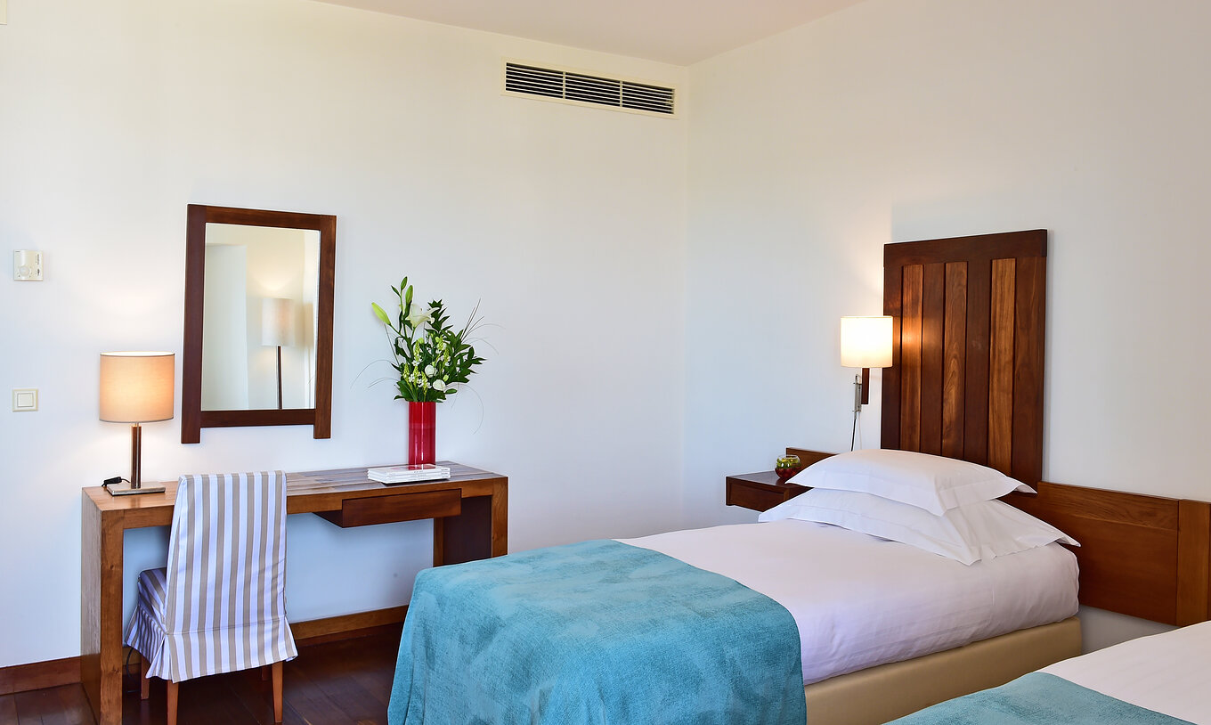 Le Chambre Supérieure de la Pousada Castelo Alcácer do Sal a un bureau avec une télévision et un miroir et deux lits séparés