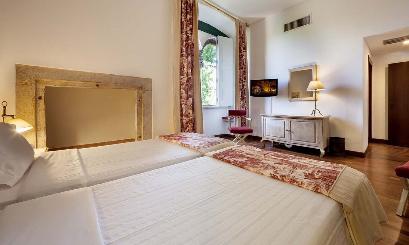 Le Chambre Classique de la Pousada Castelo Alvito a deux lits, une grande fenêtre, un meuble et une télévision