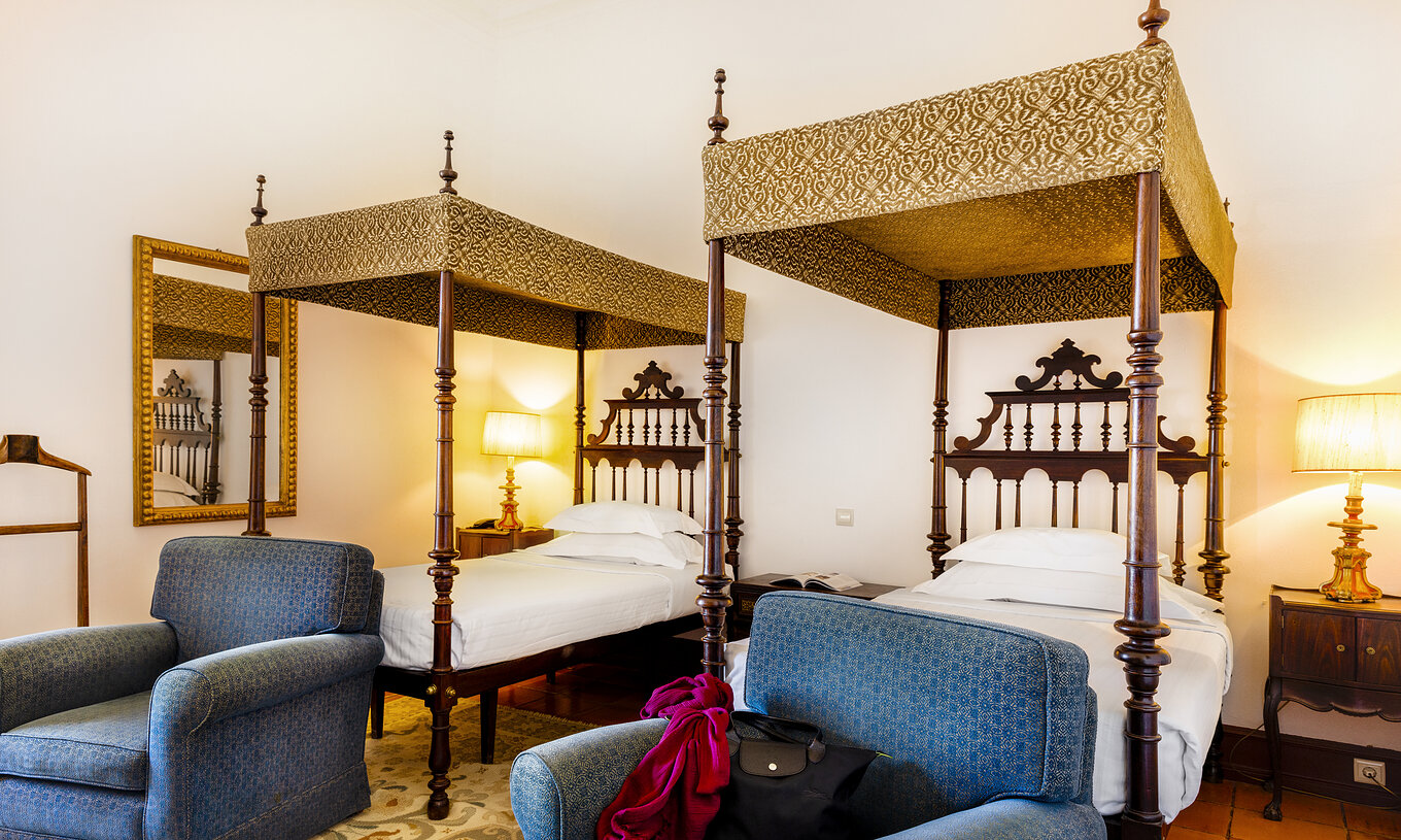 La Chambre Supérieure a deux lits, table de chevet avec lampe et deux fauteuils à la Pousada Castelo Estremoz