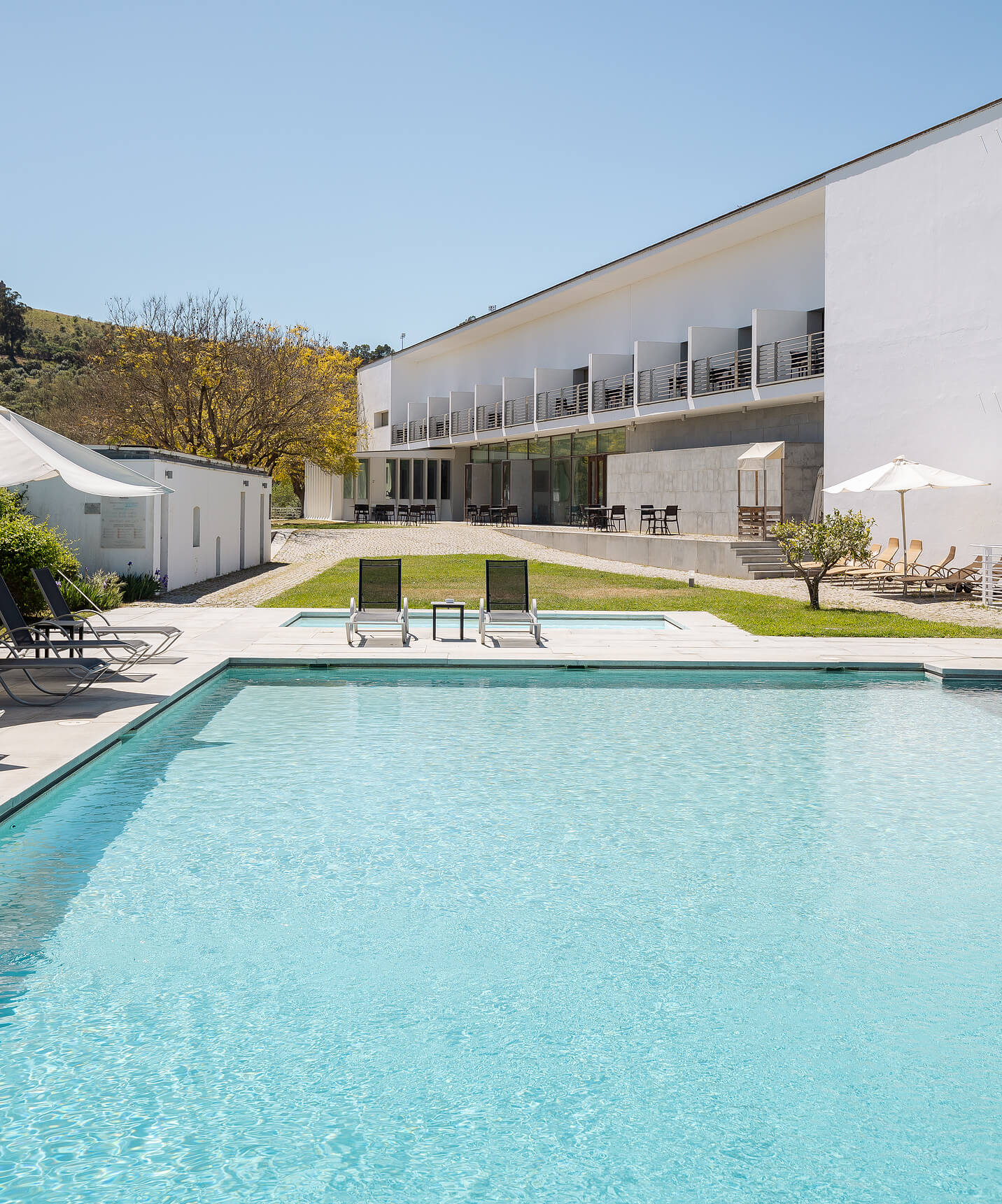 Piscine extérieure de la Pousada Convento Arraiolos avec chaises longues au cœur de la nature