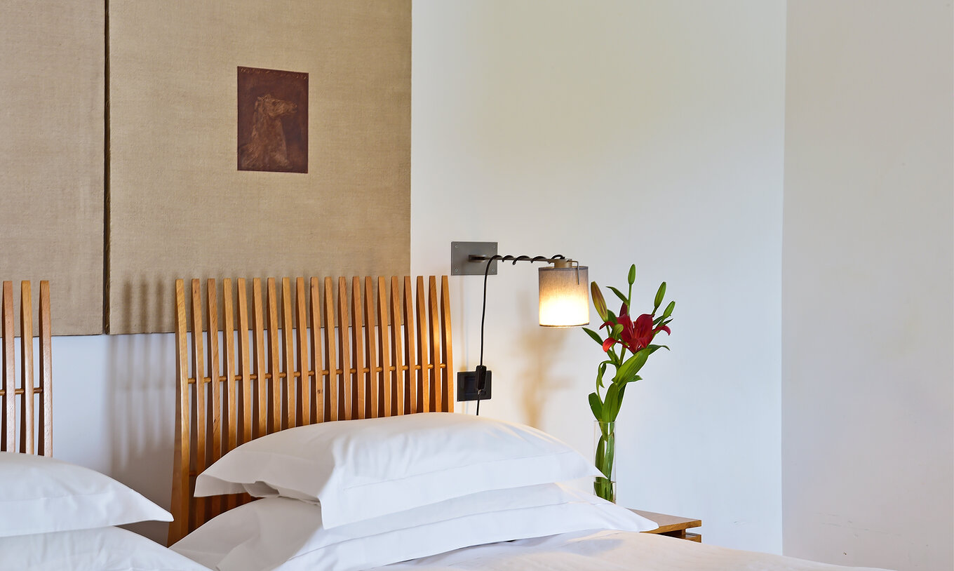Le Chambre Supérieure de la Pousada Convento Arraiolos a deux lits individuels et une table de nuit décorée avec des fleurs