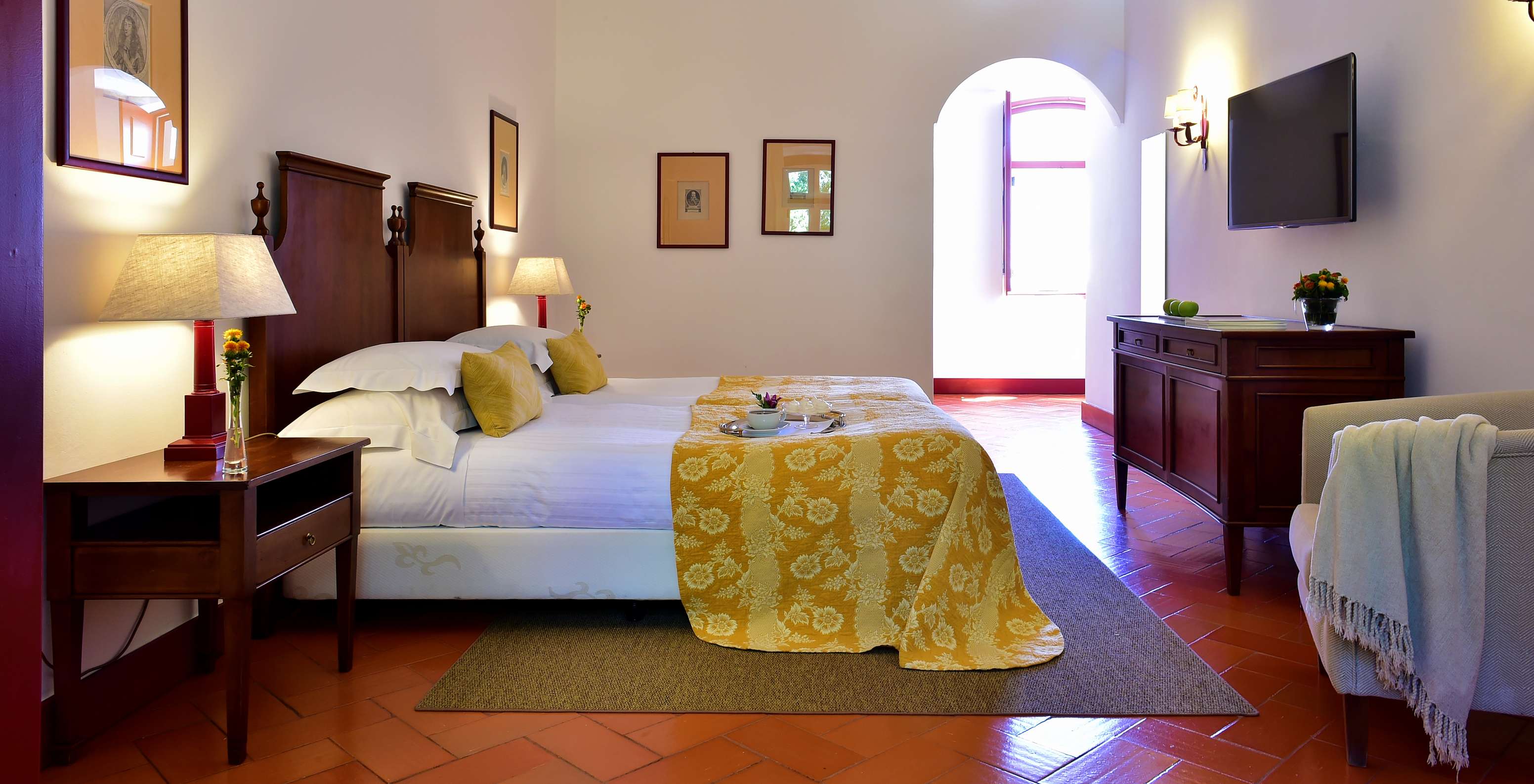 Le Chambre Pousada Family de la Pousada Convento Beja a deux lits deux tables de chevet et une télévision