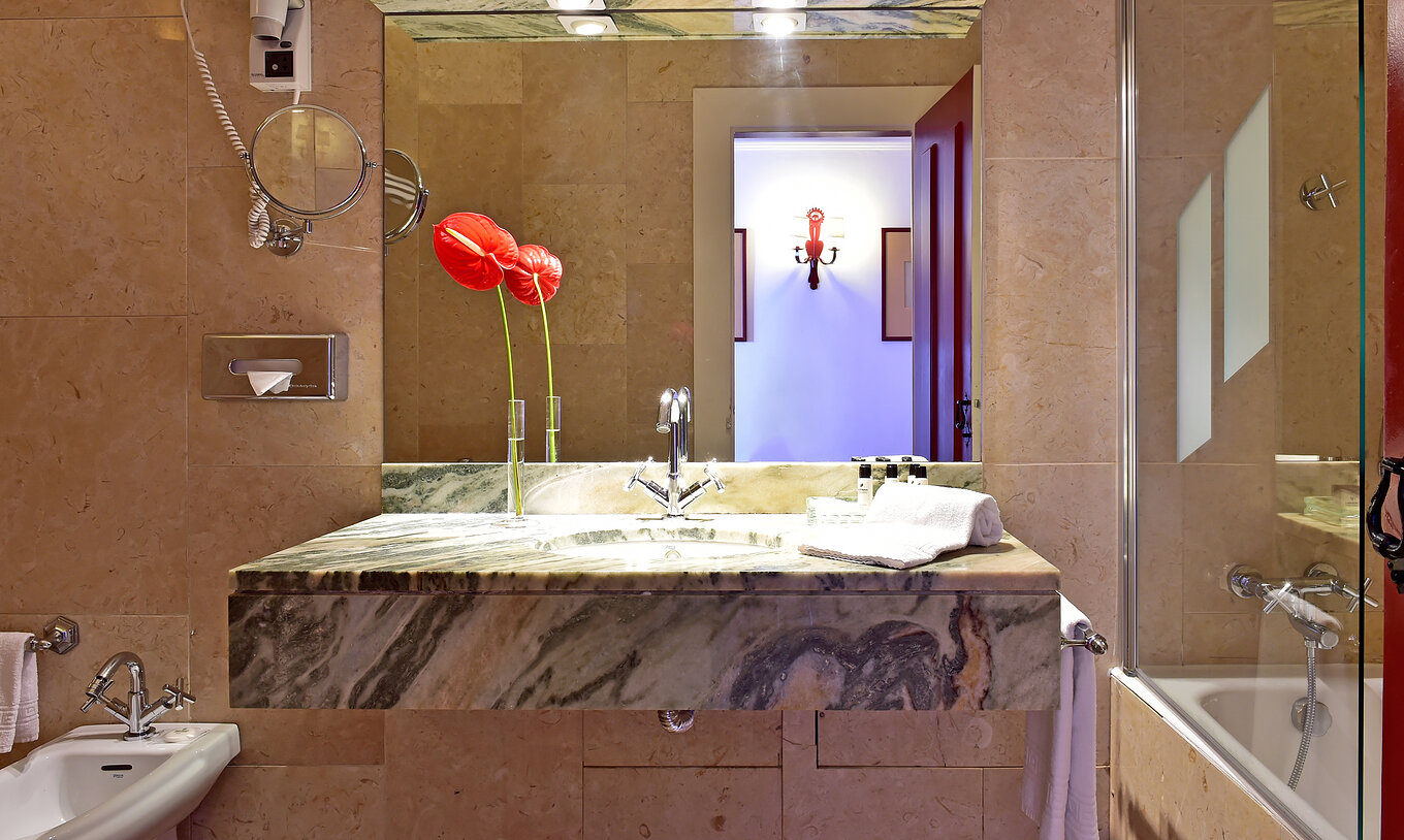 Le Chambre Classique de la Pousada Convento Beja a un balcon avec lavabo un grand miroir et une fleur