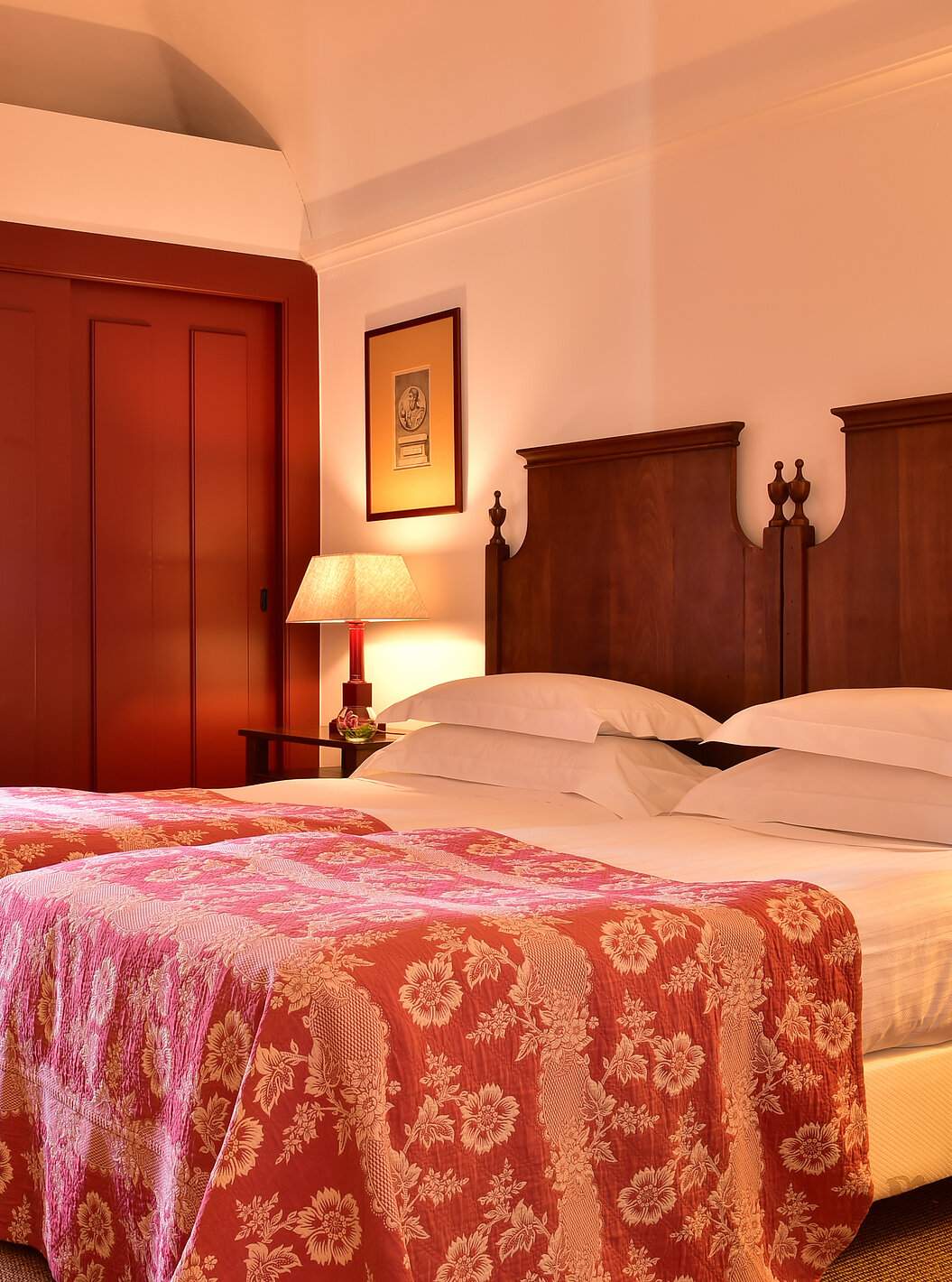 Le Chambre Classique de la Pousada Convento Beja a deux lits jumeaux avec couette rouge une fenêtre et des placards