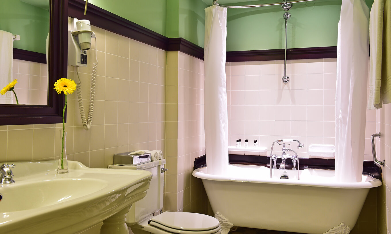 La Suite de la Pousada Convento Évora compte une salle de bain avec lavabo et baignoire avec rideau