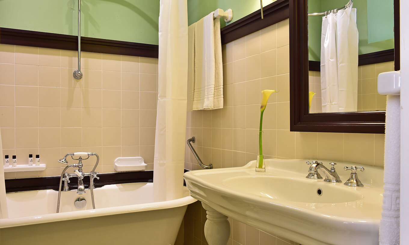 Le Supérieur Family de la Pousada Convento Évora compte une salle de bain avec lavabo et baignoire avec rideau