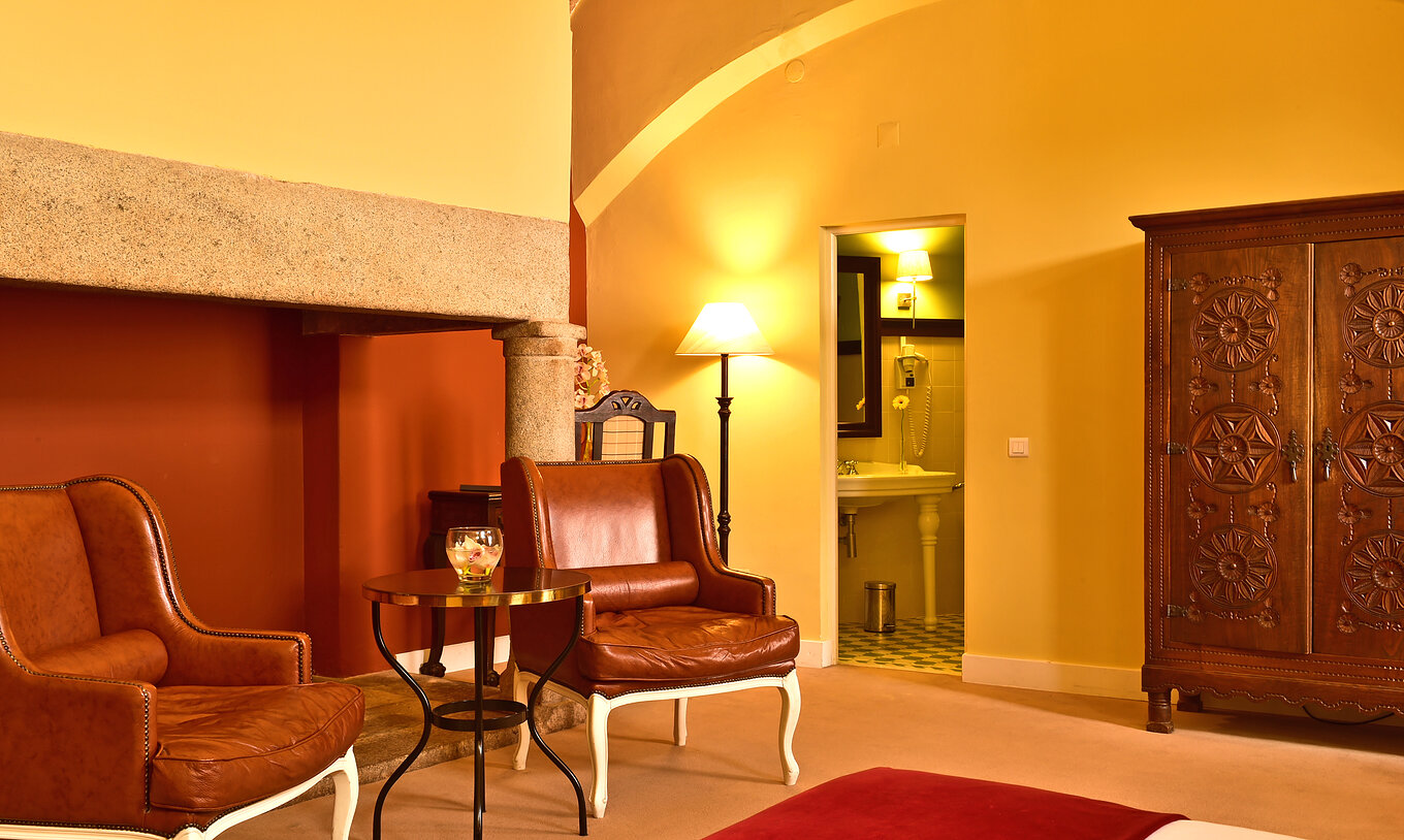 Le Supérieur Family de la Pousada Convento Évora compte deux fauteuils en cuir une salle de bain et un placard en bois