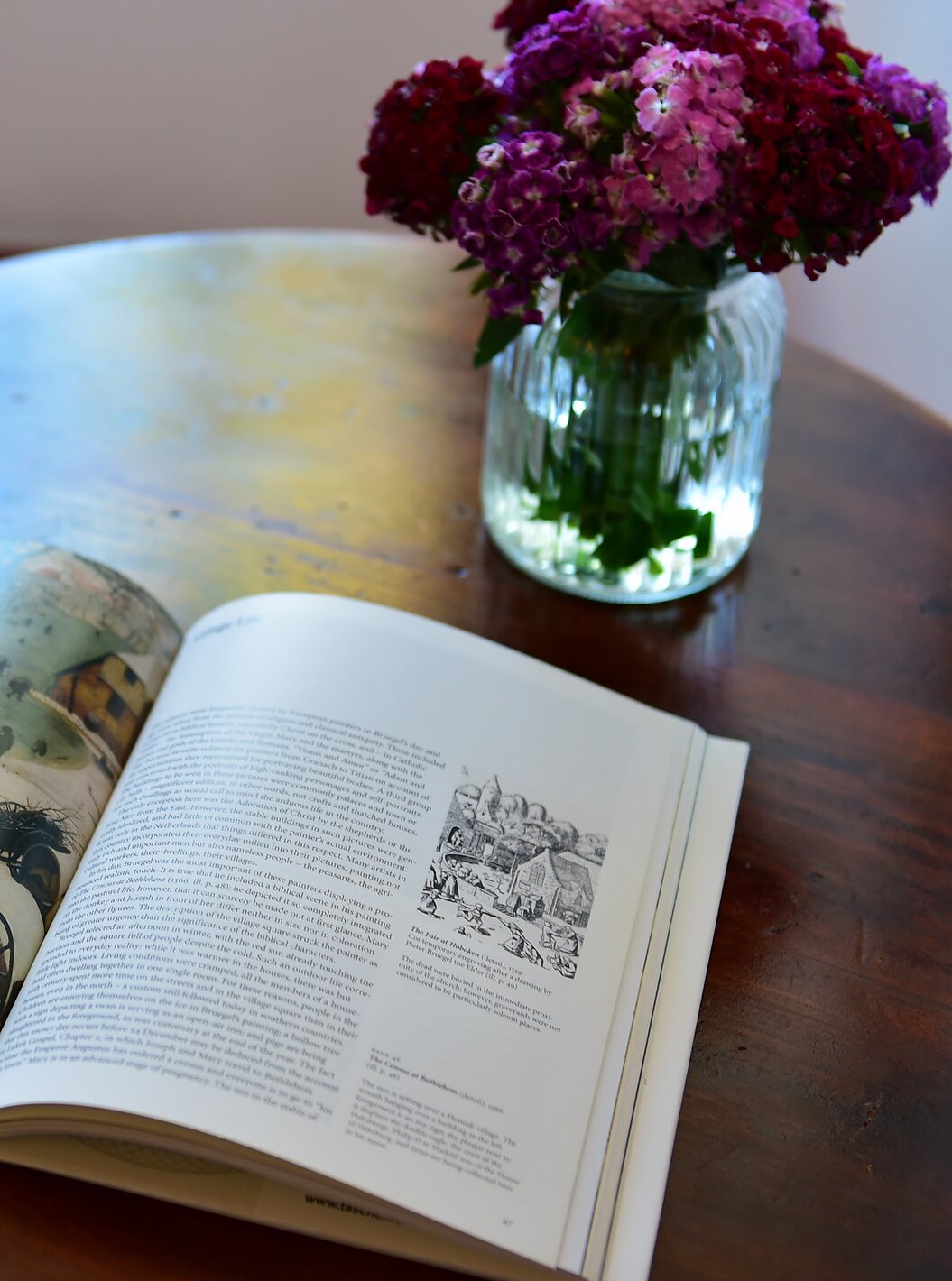 Le Studio Terrasse de la Pousada Marvão dispose d'un livre et d'un vase avec des fleurs roses et rouges