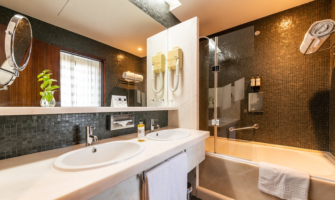 Le Chambre Classique de la Pousada Mosteiro Crato a une salle de bain en carrelage noir avec baignoire et deux lavabos