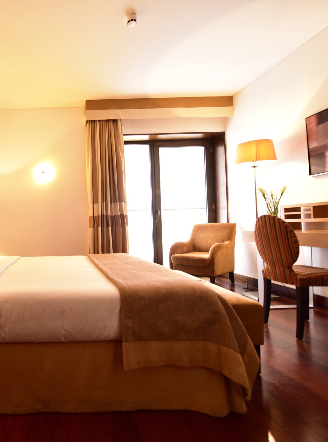 La Suite Standard de la Pousada Convento Tavira compte un lit double avec table de chevet et un bureau avec une chaise