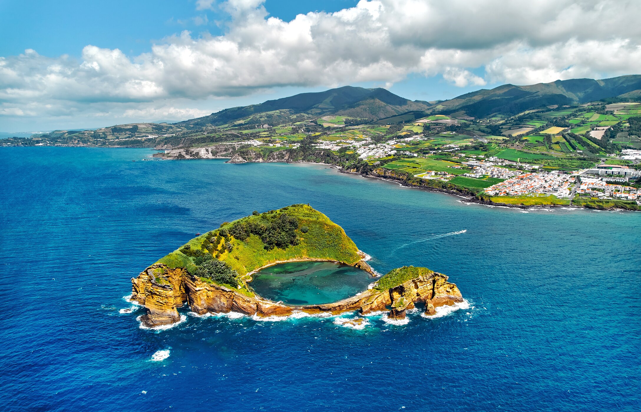 Vue panoramique de Vila Franca do Campo, avec un îlot en forme d'anneau dans l'océan et des collines vertes en arrière-plan