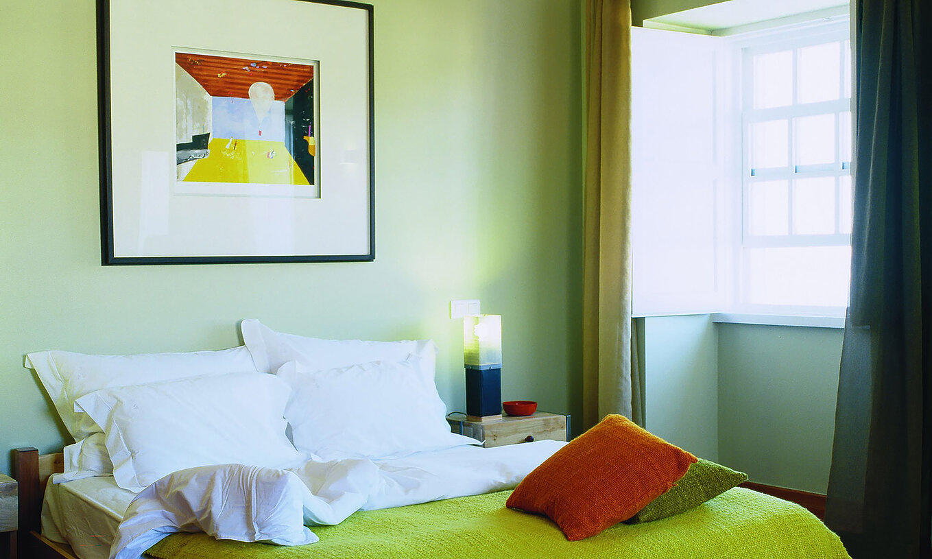 Le Chambre Supérieur de la Pousada Forte Angra do Heroísmo a un lit double avec un tableau au-dessus et une fenêtre à côté