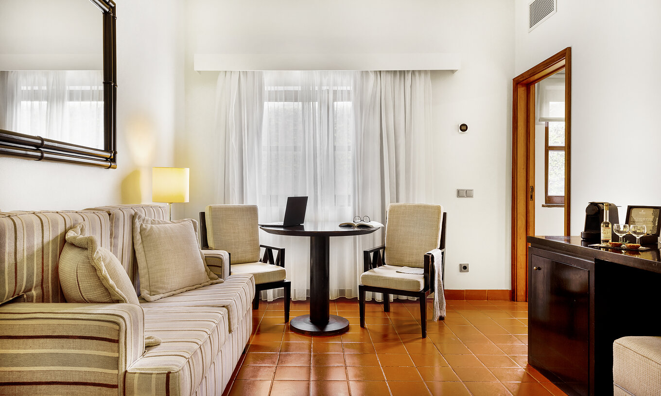 La Suite Standard de la Pousada Forte Horta a un salon avec canapé et une table avec un ordinateur et des chaises