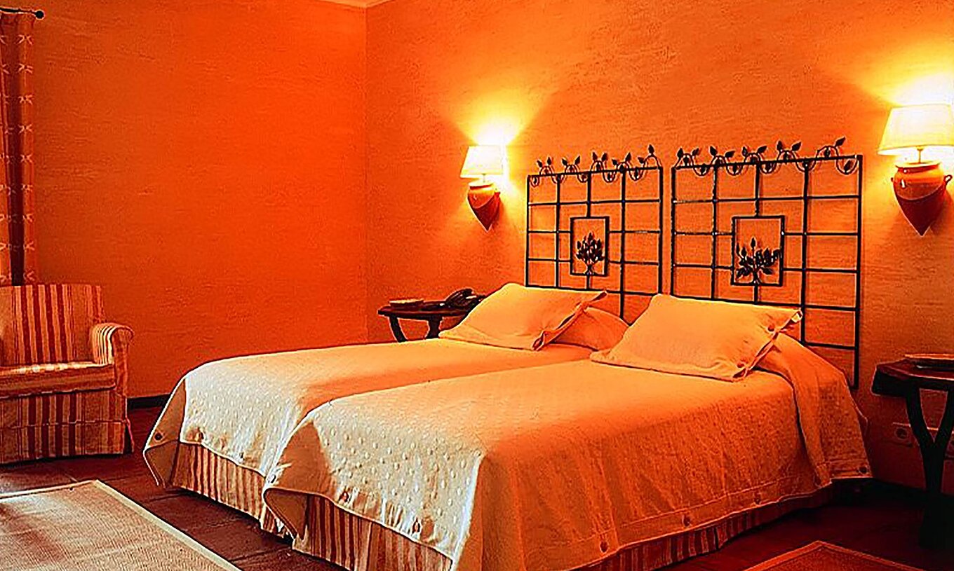 Le Twin Room - Supérieur avec Balcon de la Pousada Convento de Belmonte a deux lits simples avec un fauteuil