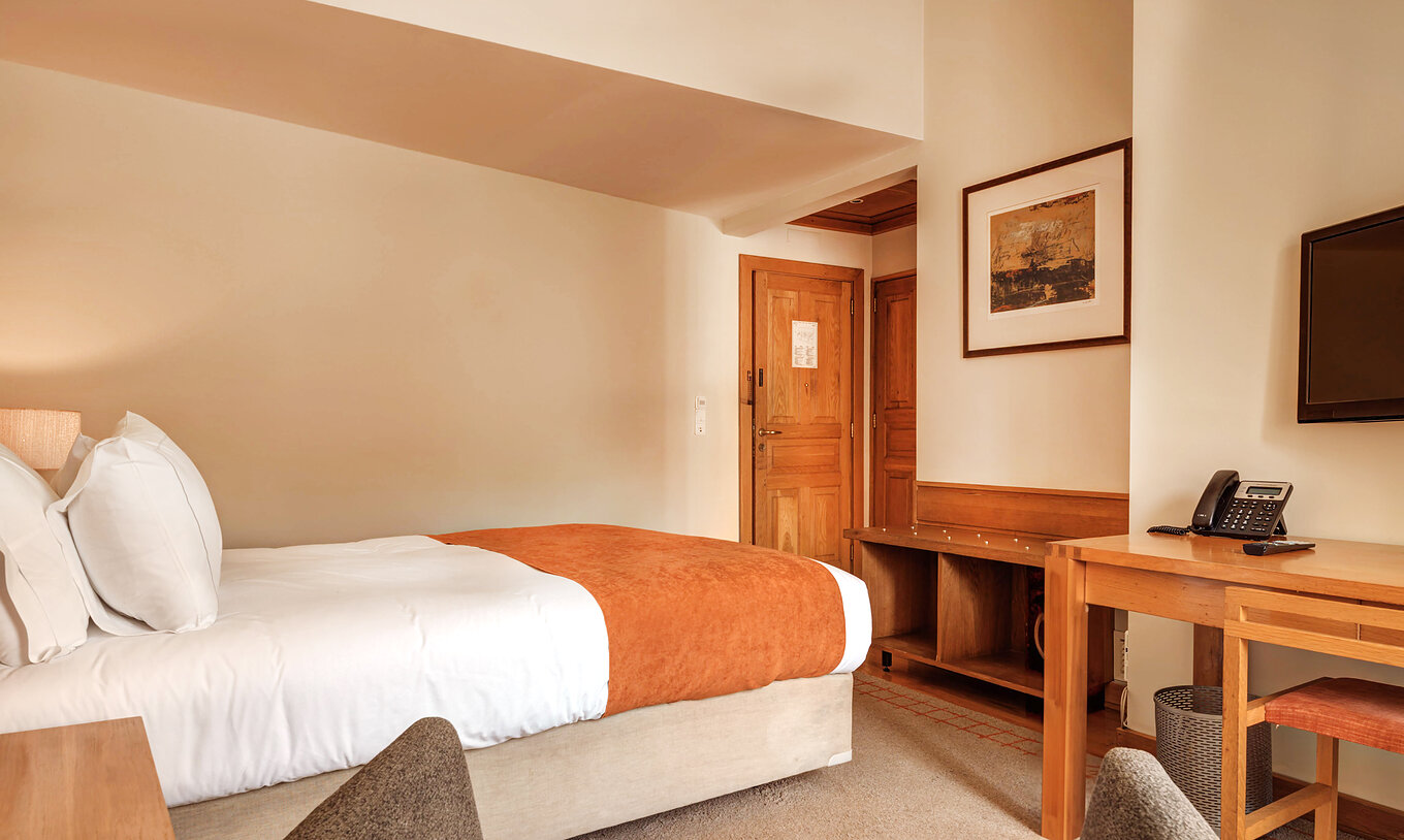 Le Chambre Famille de la Pousada Ourém a un lit double avec couette couleur brique et moquette