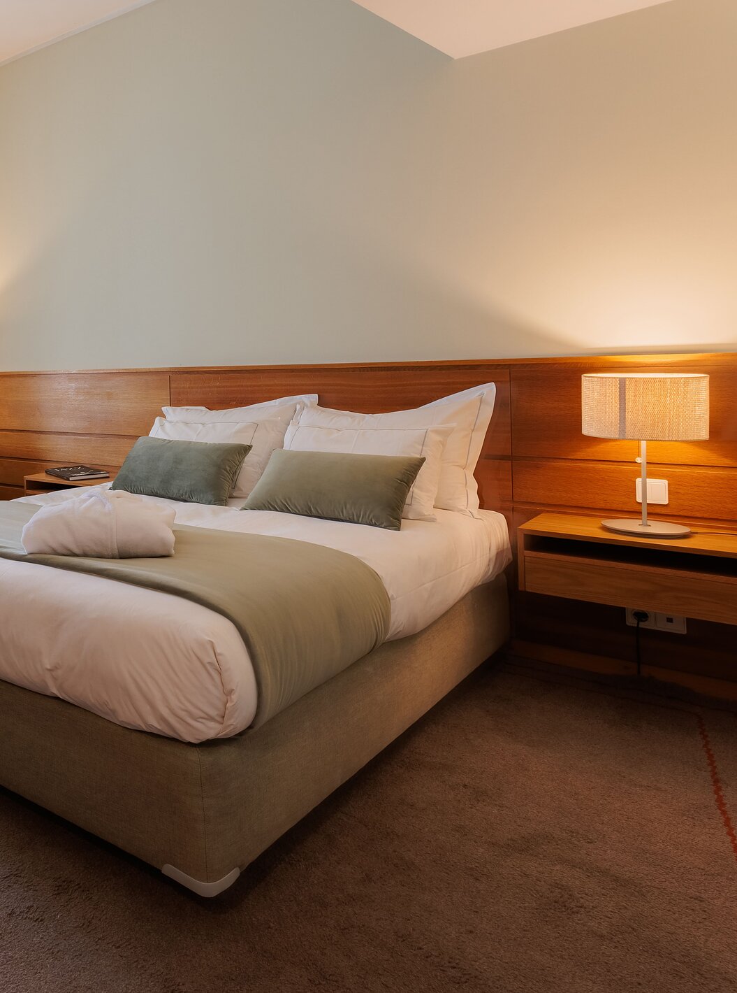 Le Chambre Famille de la Pousada Ourém a un lit double avec un peignoir sur le lit et une télévision