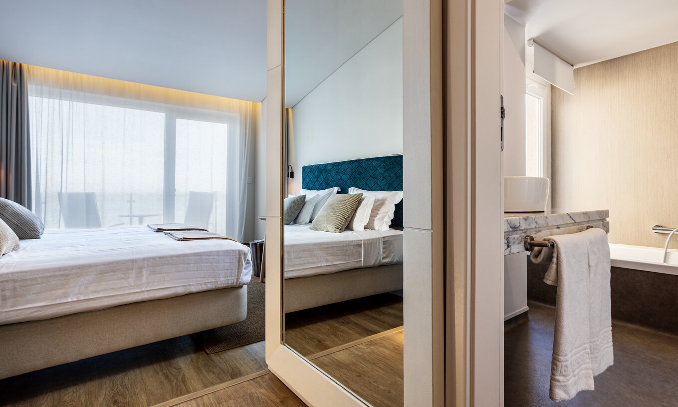 La Chambre Supérieure Large Family de la Pousada Ria - Aveiro a un lit double, miroir, et un balcon spacieux