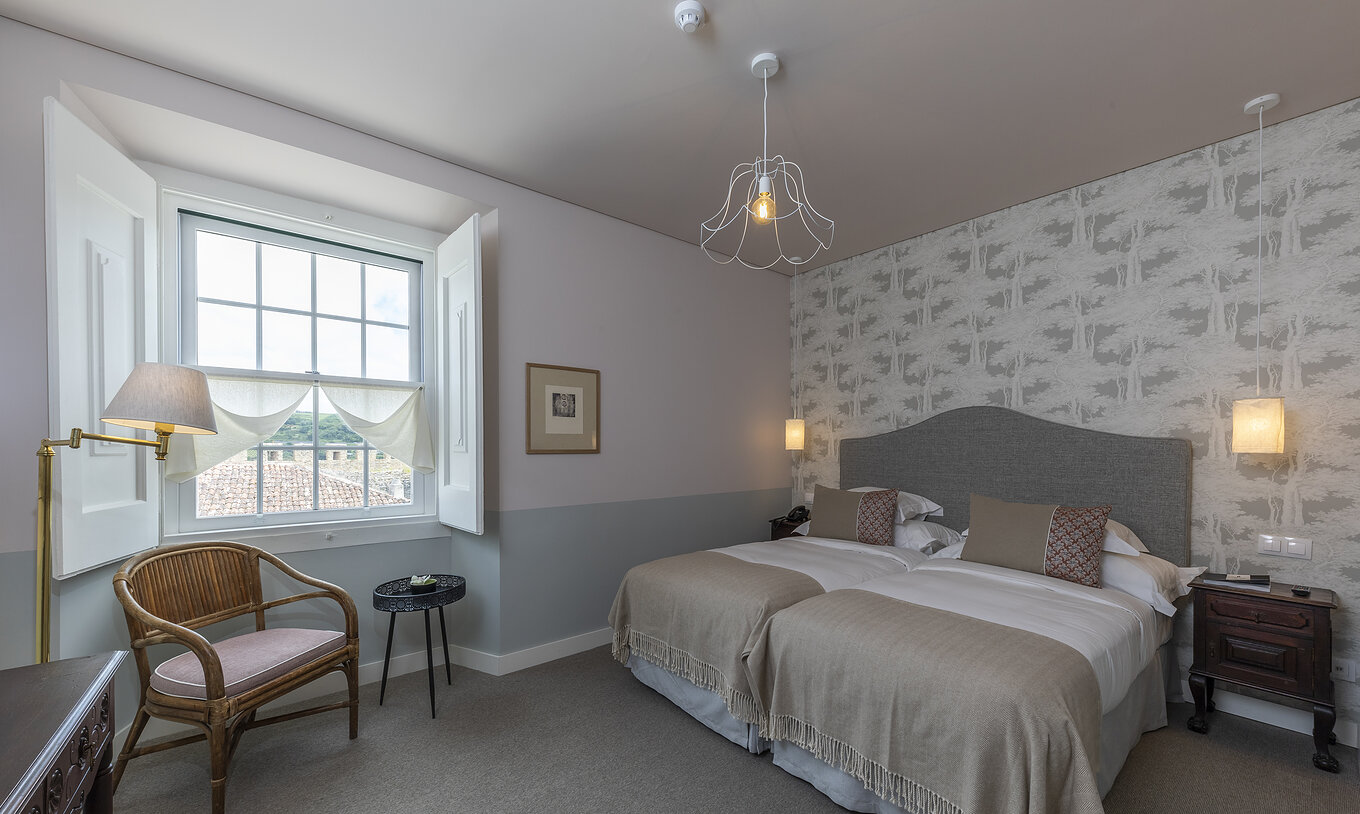 Le Chambre Supérieure de la Pousada Vila Óbidos a deux lits, papier peint avec arbres et une fenêtre