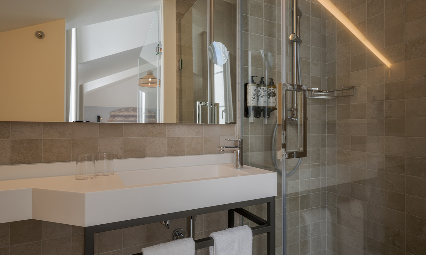 La Junior Suite River View de la Pousada Alfama a une douche à l'italienne et un large lavabo dans la salle de bain