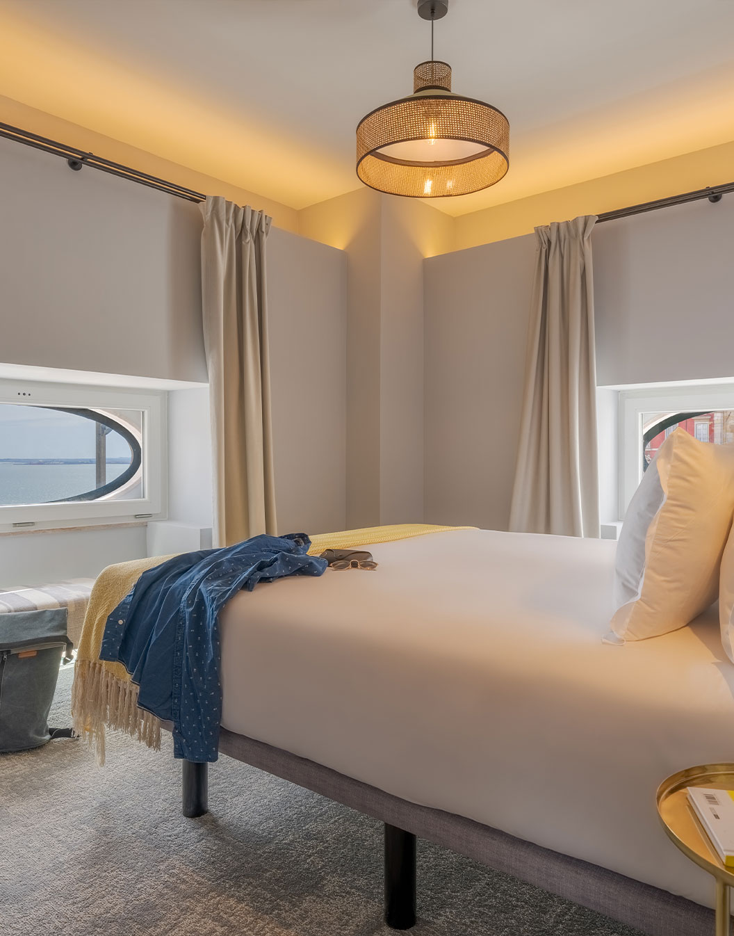 La Suite Portas do Sol de la Pousada Alfama a un lit double dans une chambre décorée en tons de jaune, avec une fenêtre ronde