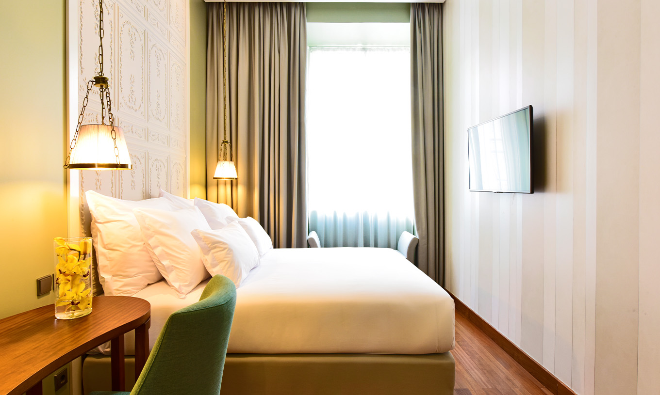 Le Cozy Queen Size Bed de la Pousada Lisboa Praça do Comércio a un lit double avec un bureau à côté et une grande fenêtre