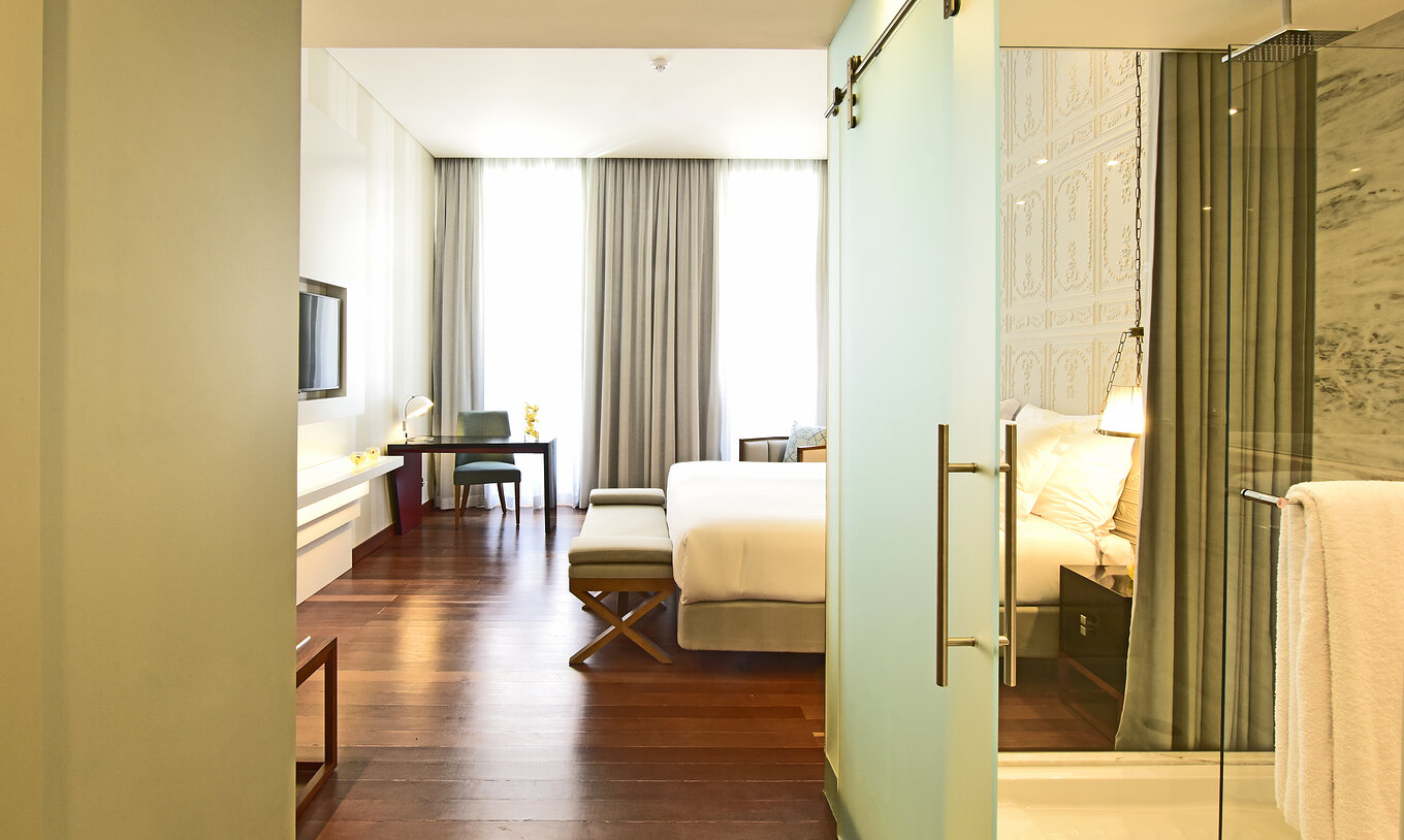 Le lit Deluxe King Size de la Pousada de Lisboa Praça do Comércio a une salle de bain avec paroi en verre et lit double