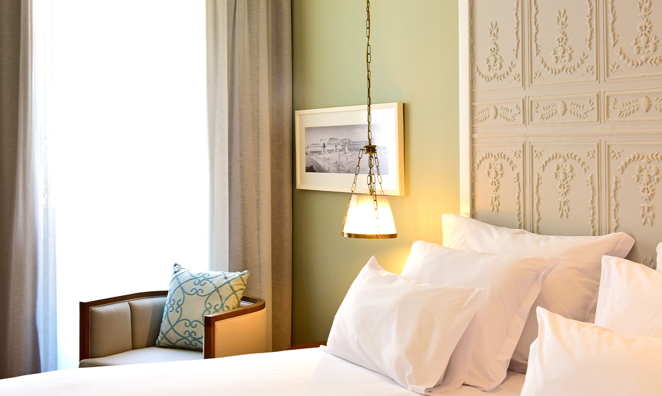 Le Superior King Size Bed de la Pousada Lisboa Praça do Comércio a une lampe suspendue un lit double et une fenêtre