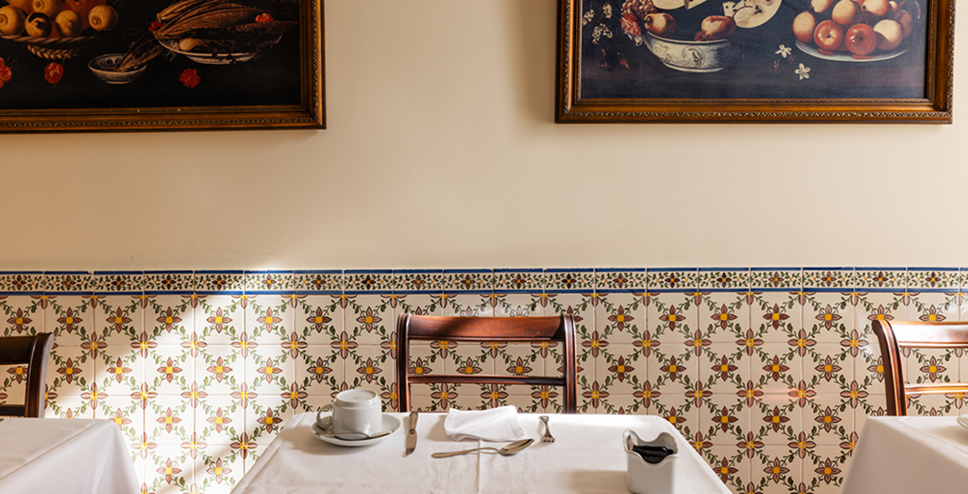 Salle de petit-déjeuner dans un hôtel historique à Queluz, avec une table et deux tableaux au-dessus de la table