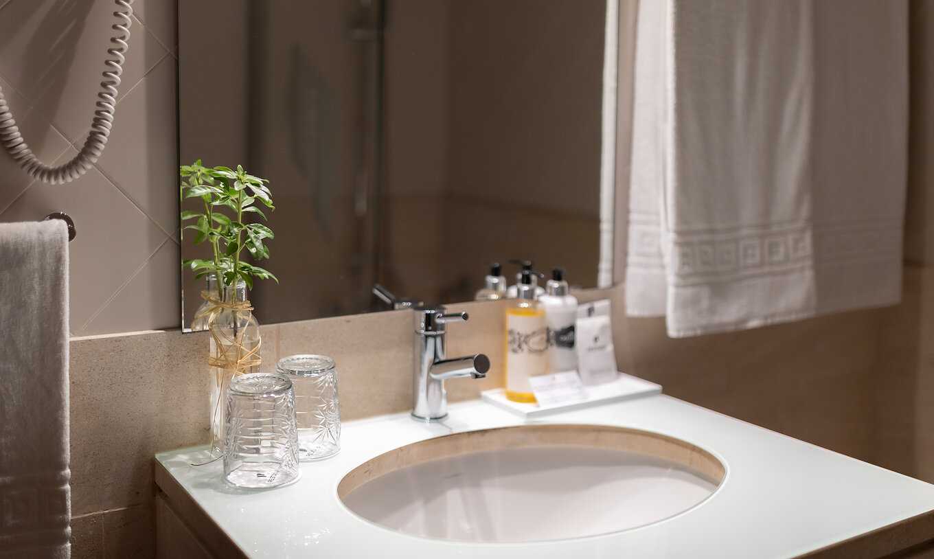 Chambre Supérieure de la Pousada Caniçada - Gerês avec salle de bain, serviettes, lavabo avec miroir et amenities