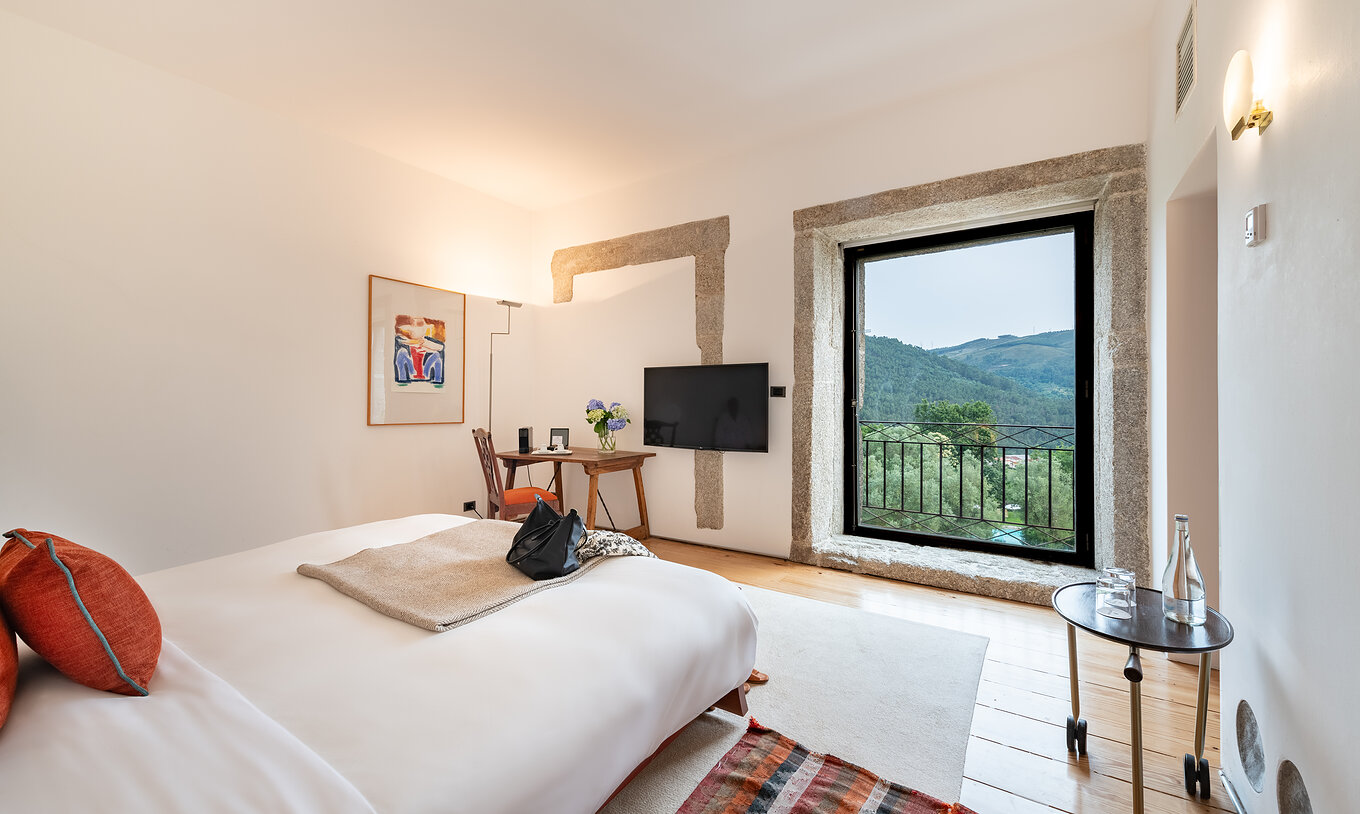 La Suite Standard de la Pousada Mosteiro Amares a un lit double avec une grande fenêtre avec vue sur la nature