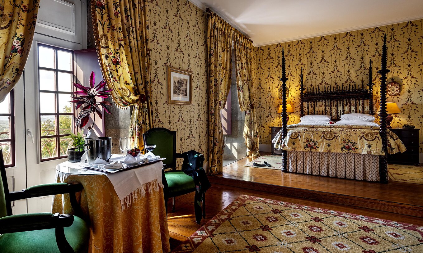 La Master Suite de la Pousada Mosteiro Guimarães a un lit double, deux fenêtres et une table avec deux chaises