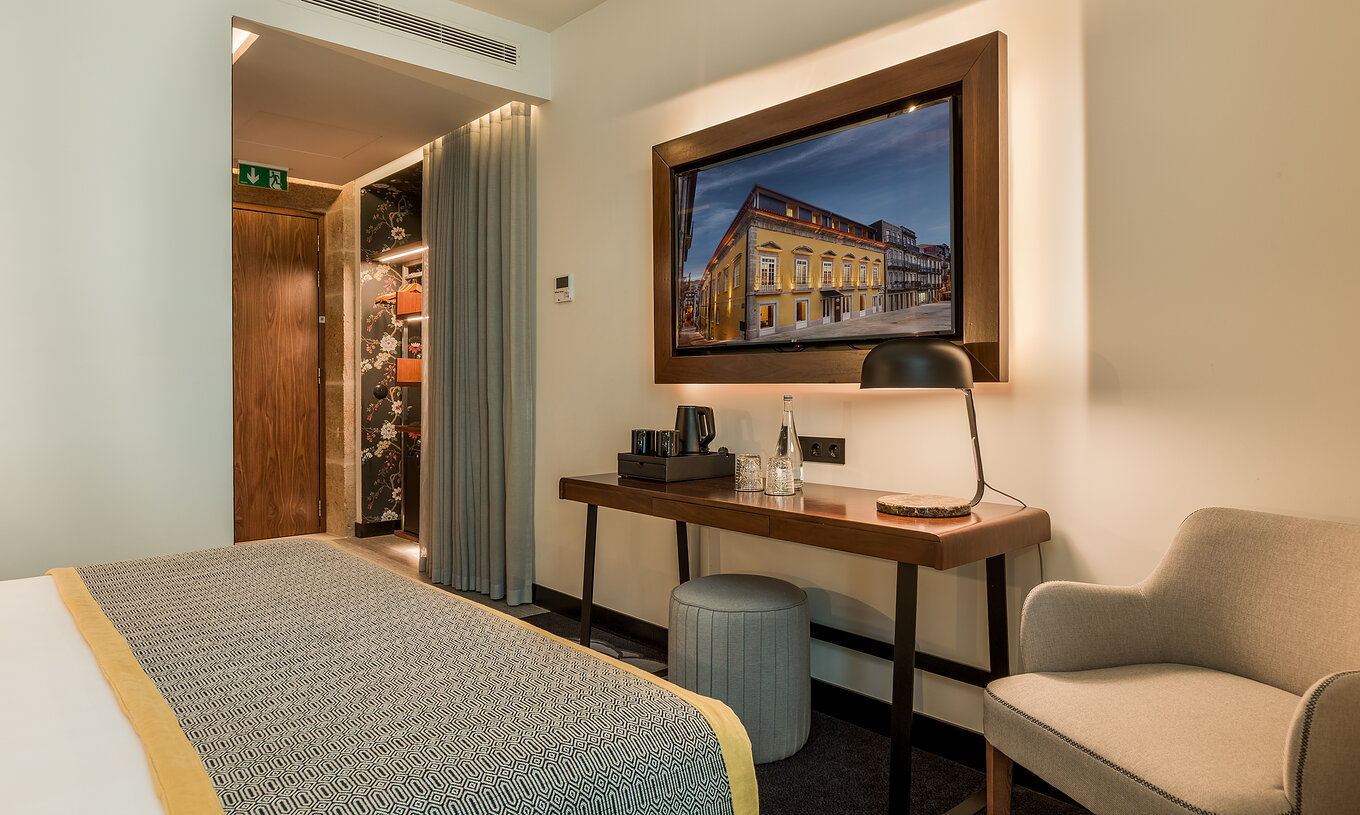 Le Deluxe de la Pousada Porto dispose d'un bureau et d'une télévision en face du lit, d'un fauteuil et d'un pouf