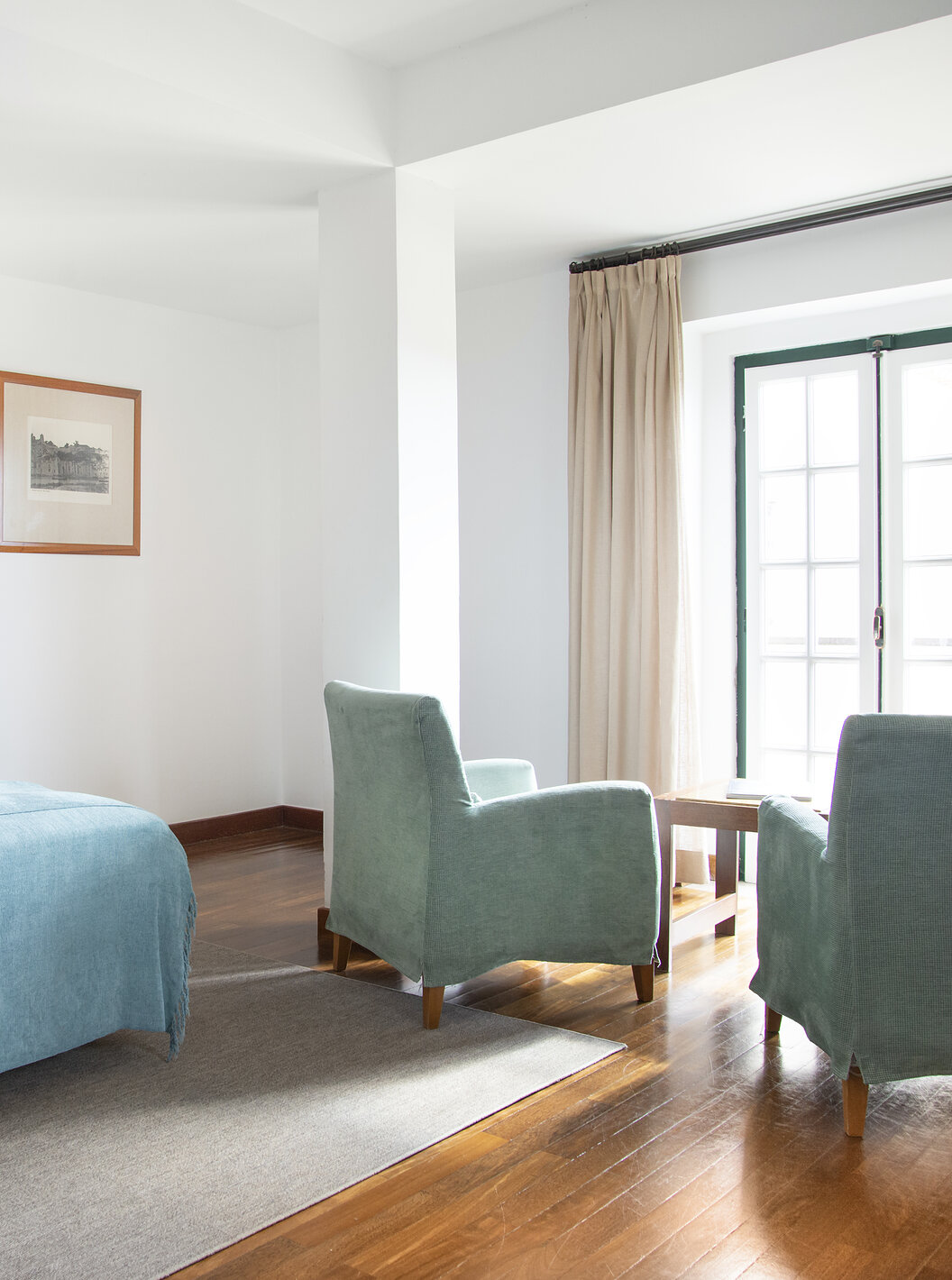 De Junior Suite van Pousada Castelo Alcácer do Sal heeft een tweepersoonsbed met een blauwe dekbed en twee fauteuils