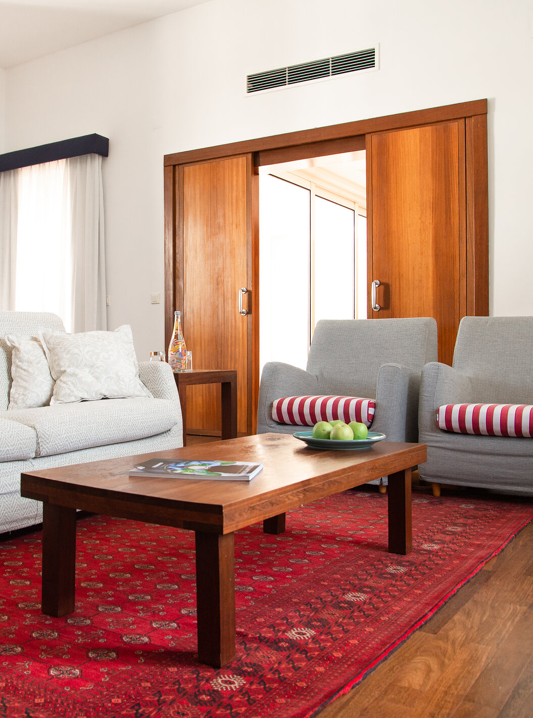 De Speciale Suite van Pousada Castelo Alcácer do Sal heeft een bank, twee fauteuils, een rood tapijt en een tafel