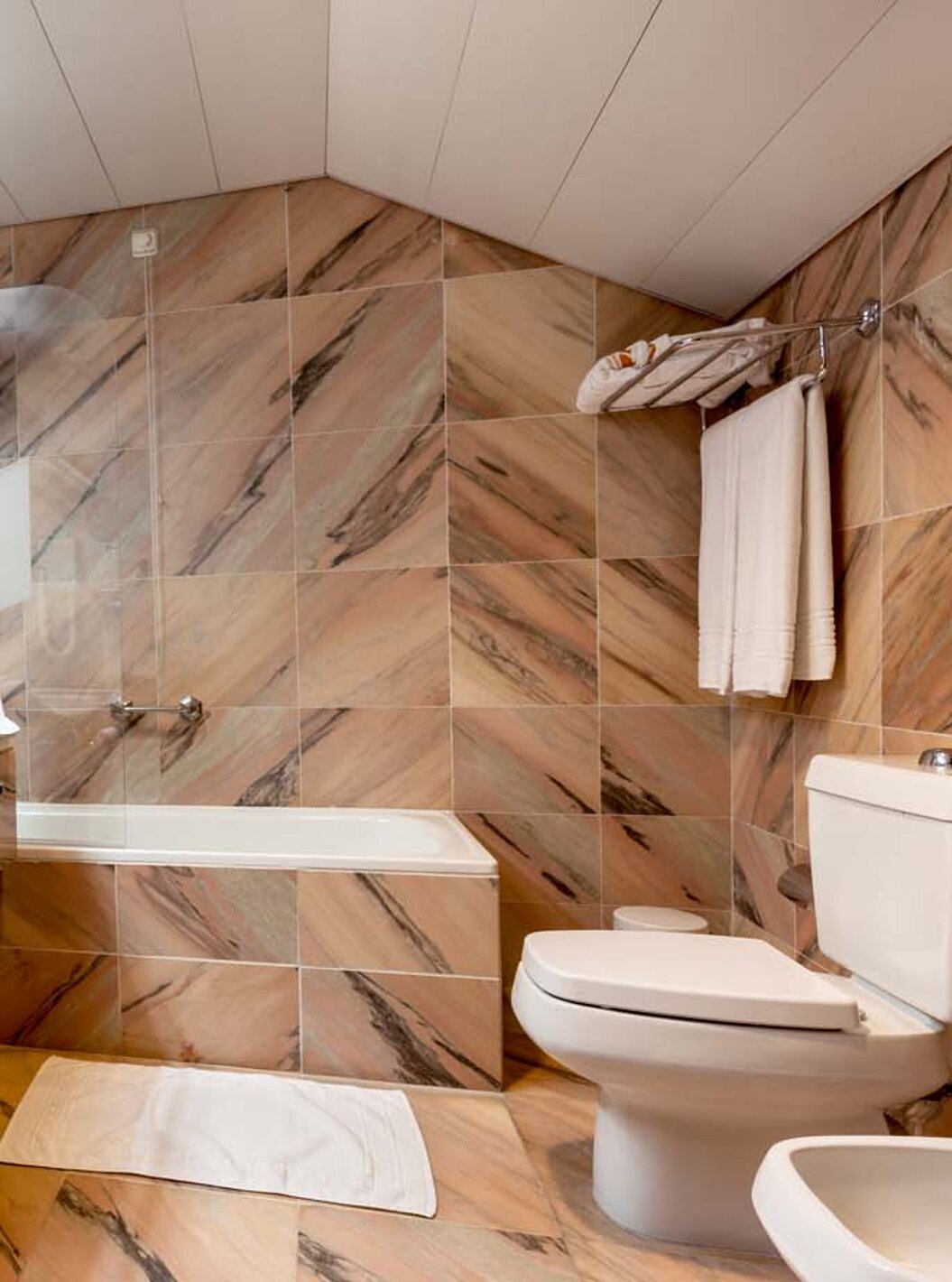 De Standaard Suite van Pousada Castelo Alvito heeft een marmeren badkamer met wastafel, toilet en bad met douche.