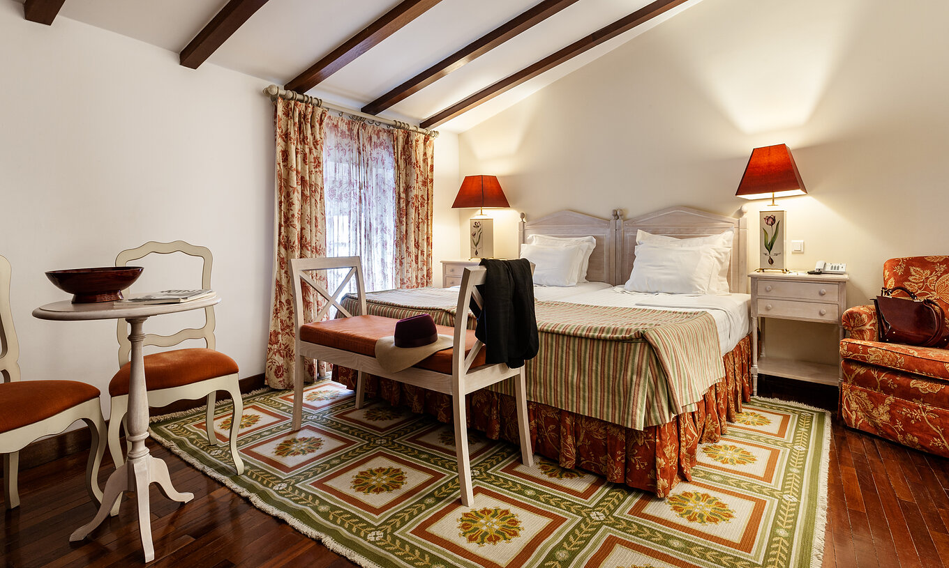 Het Superior Suite met Balkon van Pousada Marvão heeft een tweepersoonsbed, een bank aan het voeteneinde en een fauteuil