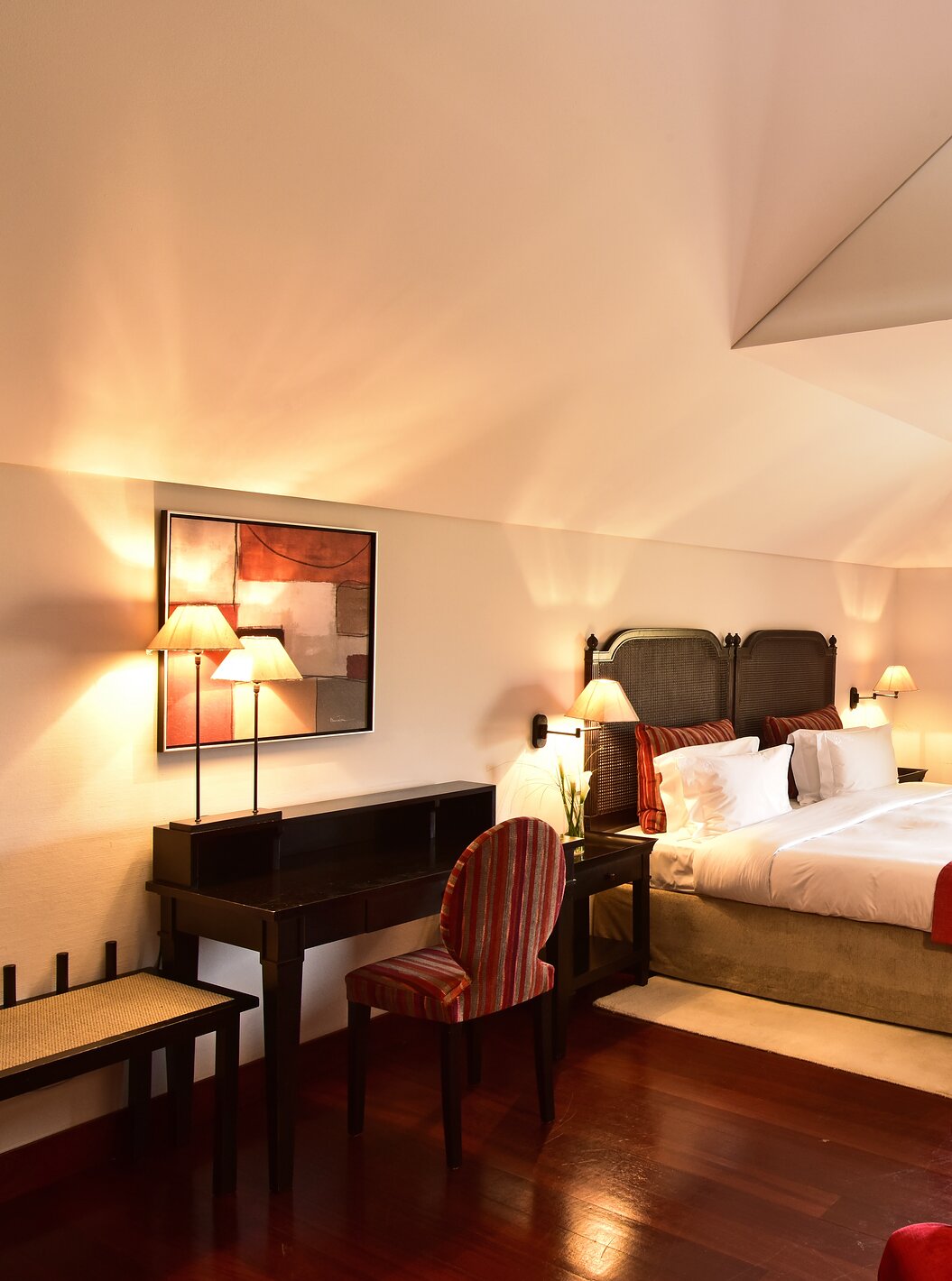 De Standaard Suite van Pousada Convento Tavira heeft een kamer met tweepersoonsbed en bureau en een trap naar de woonkamer