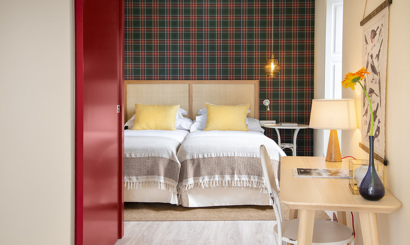 De Superior Kamer van Casa Lidador - Óbidos heeft twee eenpersoonsbedden, ruitjesbehang, raam en een bureau