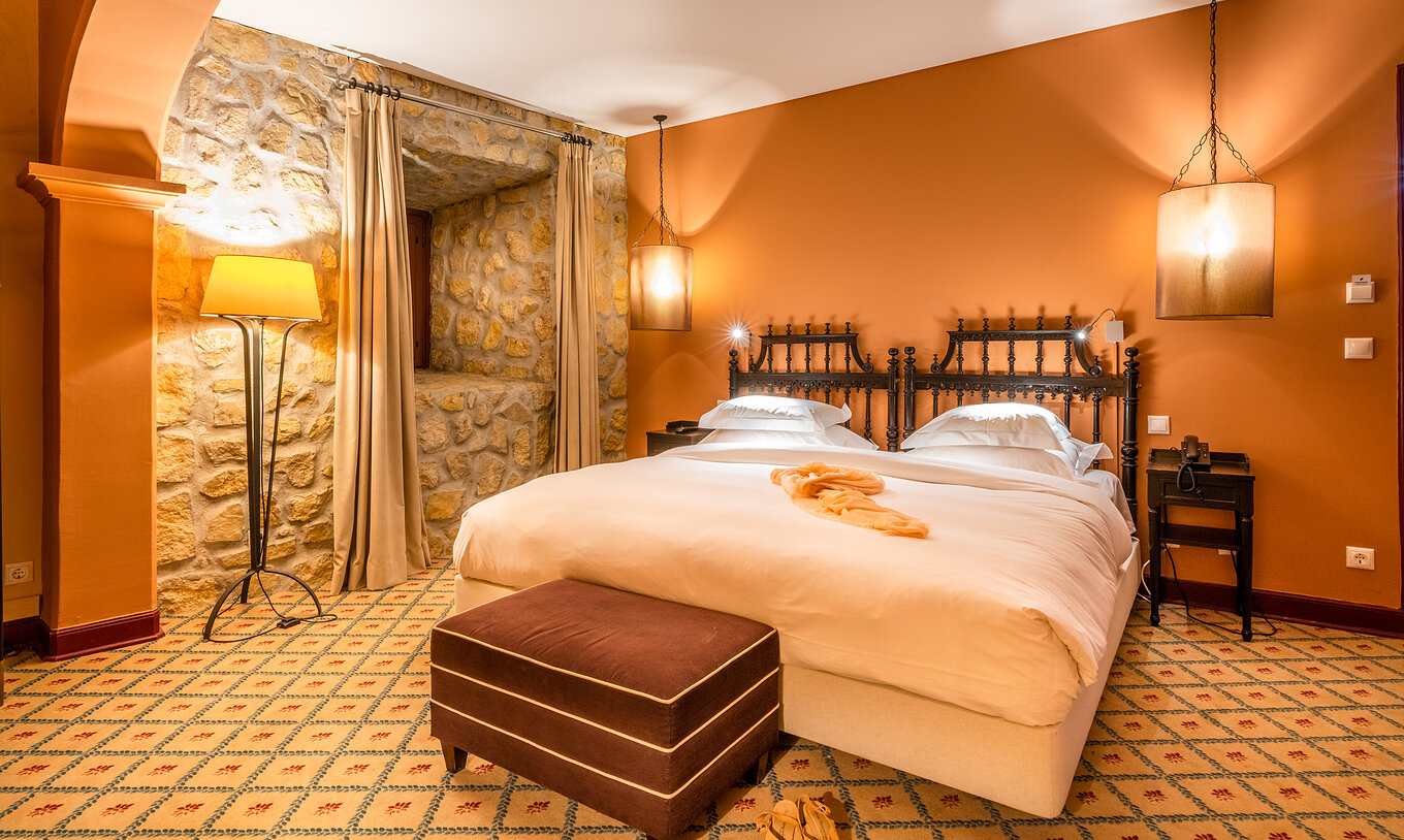 De Superior Kamer Casa do Castelo van Pousada Castelo Óbidos heeft een tweepersoonsbed met nachttafel en telefoon