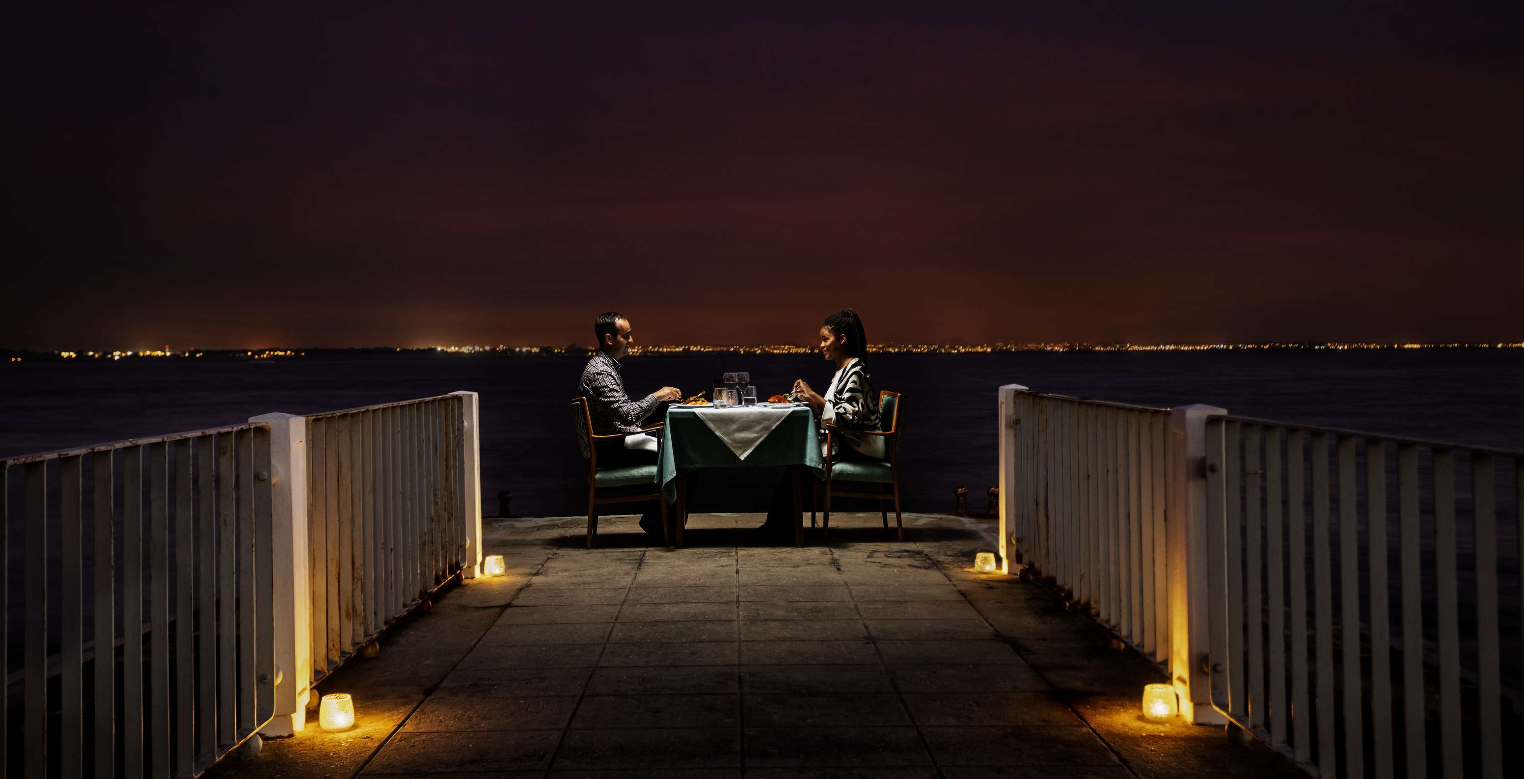 Romantisch diner voor twee bij kaarslicht met panoramisch uitzicht op de ria