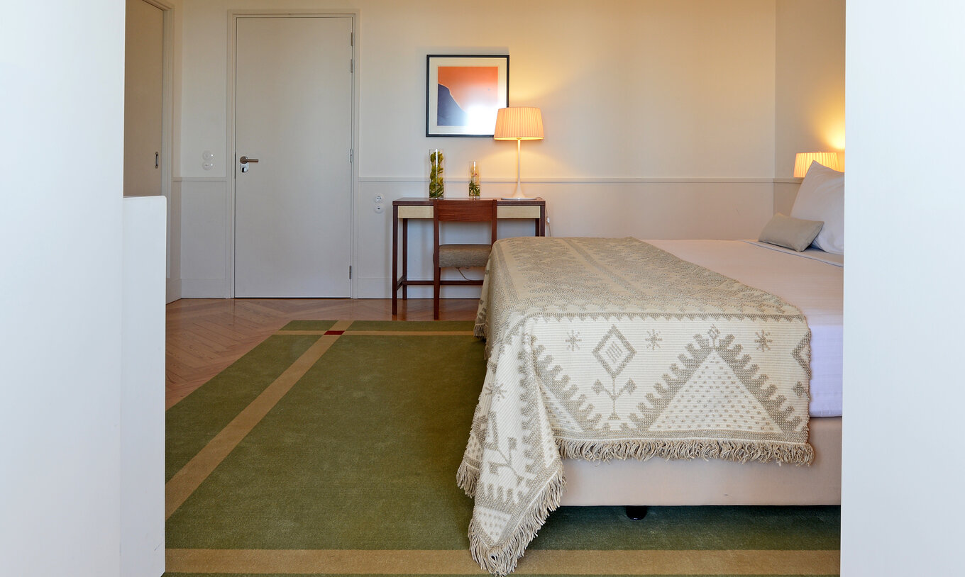 De Junior Suite Pousada Serra da Estrela heeft een bed en schilderij