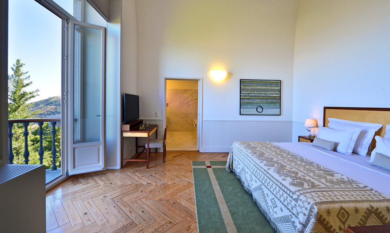De Presidentiële Suite Pousada Serra da Estrela heeft een bed en balkon met uitzicht