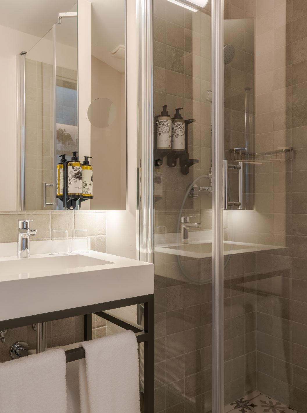 Klassiek in Pousada Alfama heeft een moderne badkamer met douche, witte wastafel, witte handdoeken en spiegel