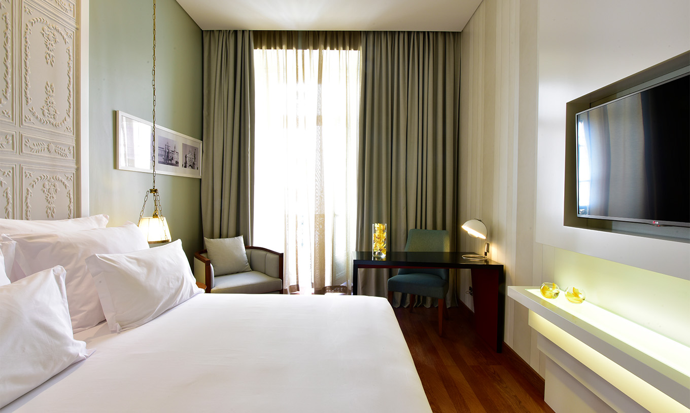 Het Classic King Size Bed van Pousada Lisboa Praça do Comércio heeft een tweepersoonsbed, bureau en een groot raam  