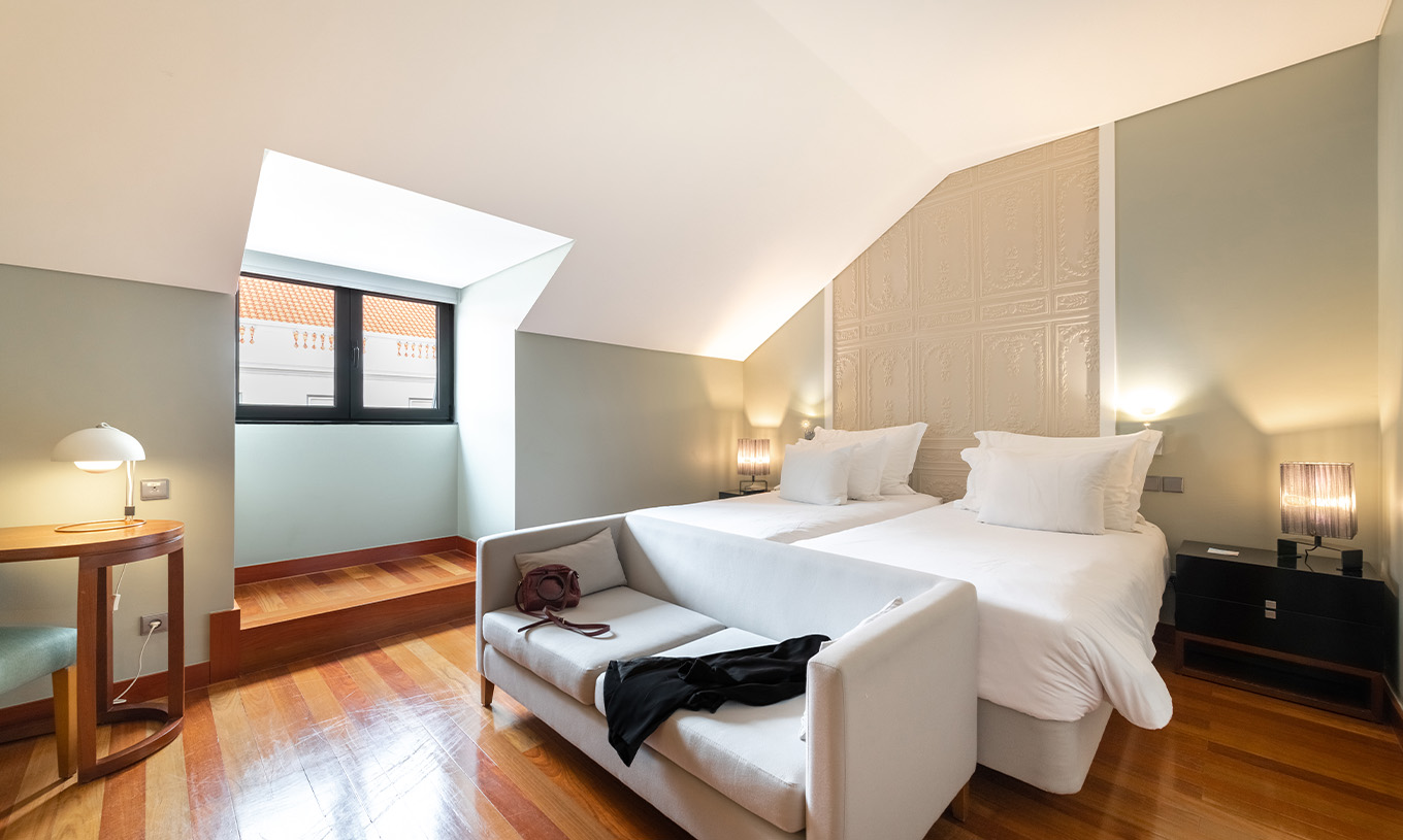 Het Superior King Size Bed van Pousada Lisboa Praça do Comércio heeft twee eenpersoonsbedden en een bank en een raam  