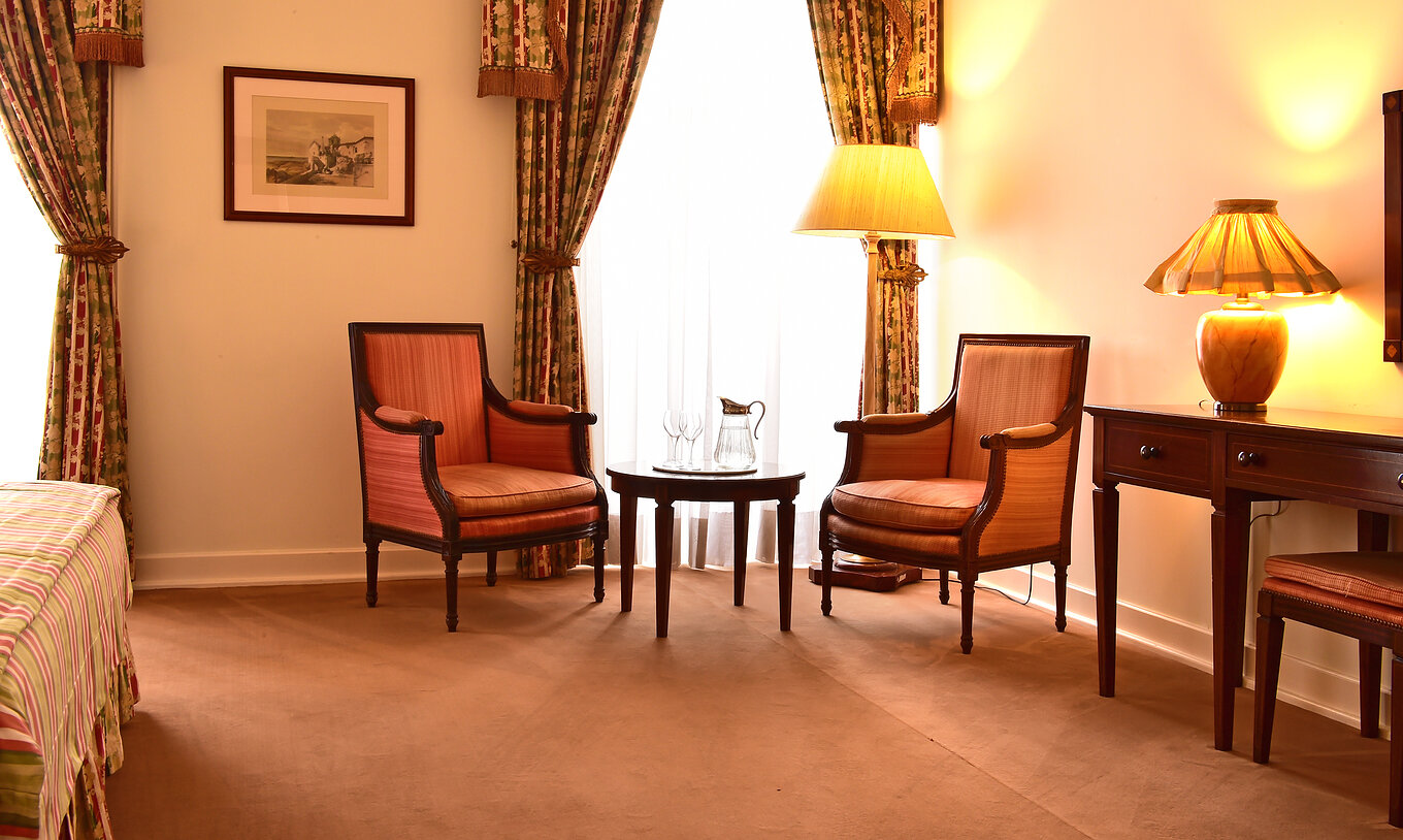 Het Superior Room van Pousada Palácio Queluz heeft een zithoek met twee banken, een salontafel en ramen