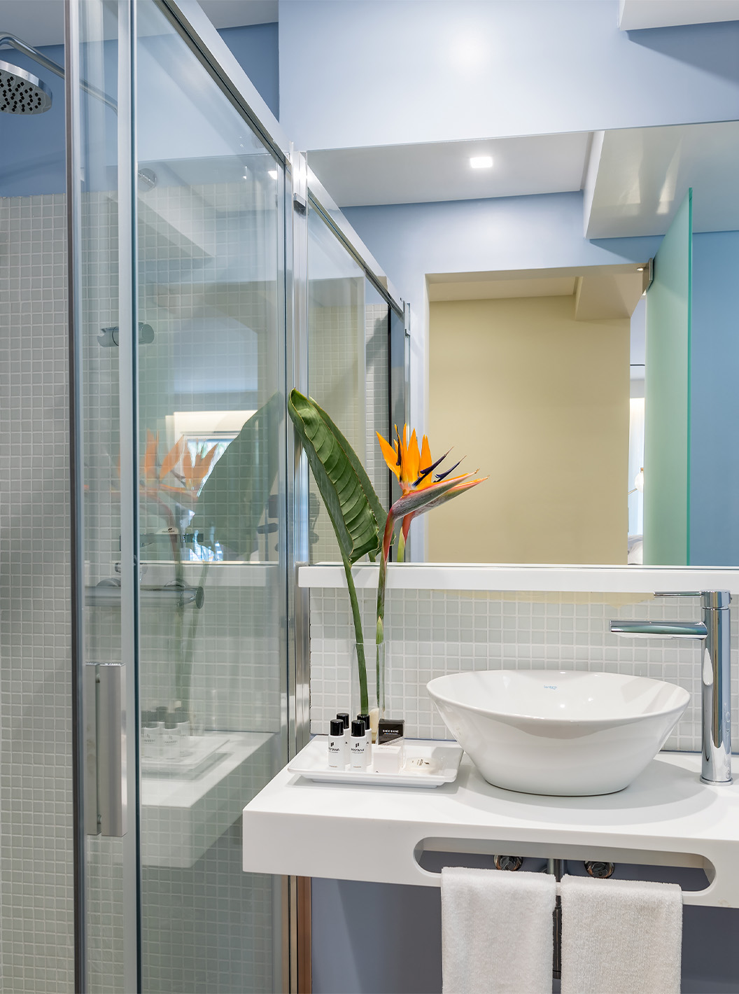 De Deluxe Bay View Room van Pestana Churchill Bay heeft een badkamer in blauwtinten, met amenities, wastafel en douche