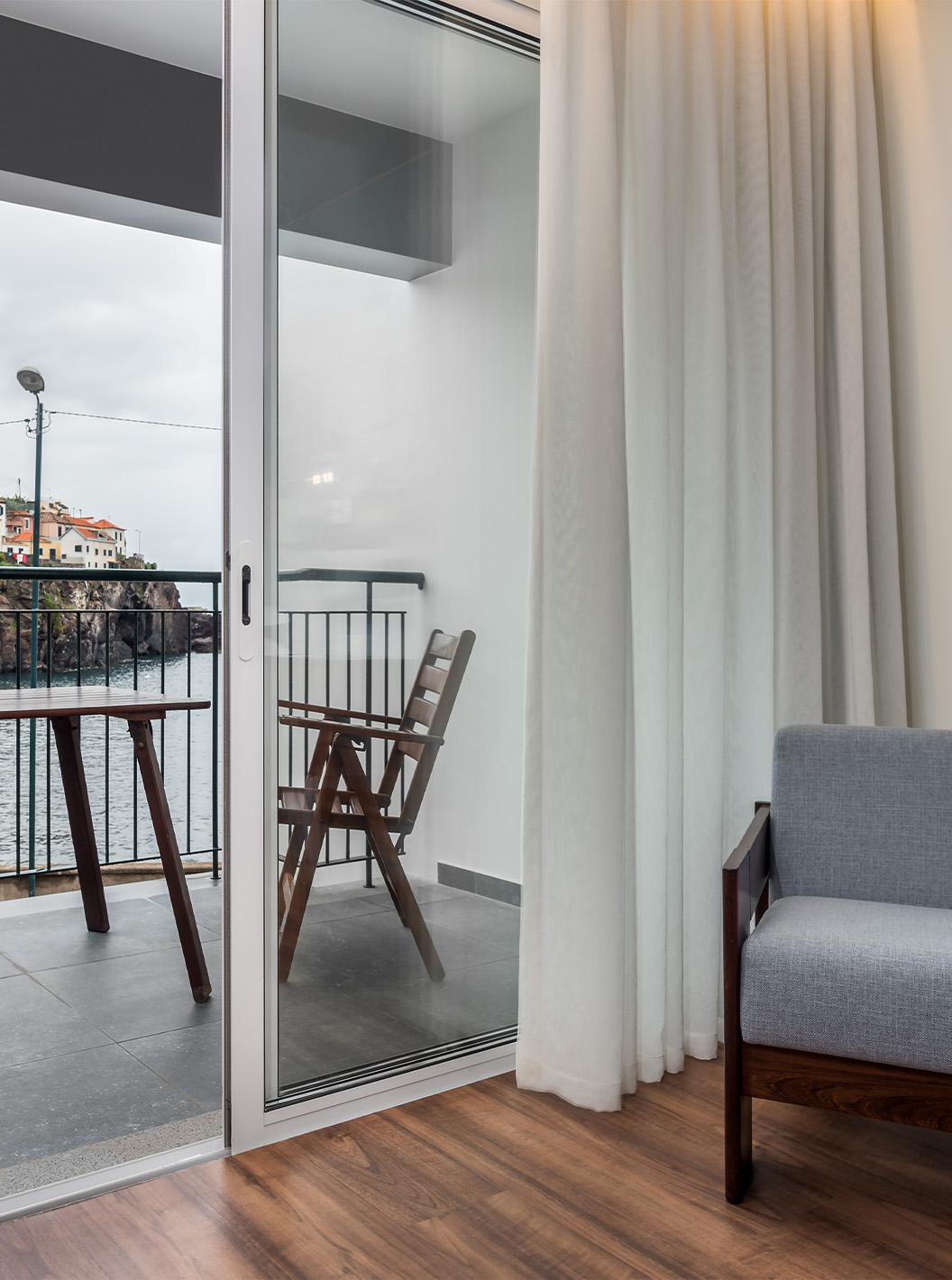 De Deluxe Superior Family Bay View Room van Pestana Churchill Bay heeft een balkon met zeezicht en een tafel met stoelen