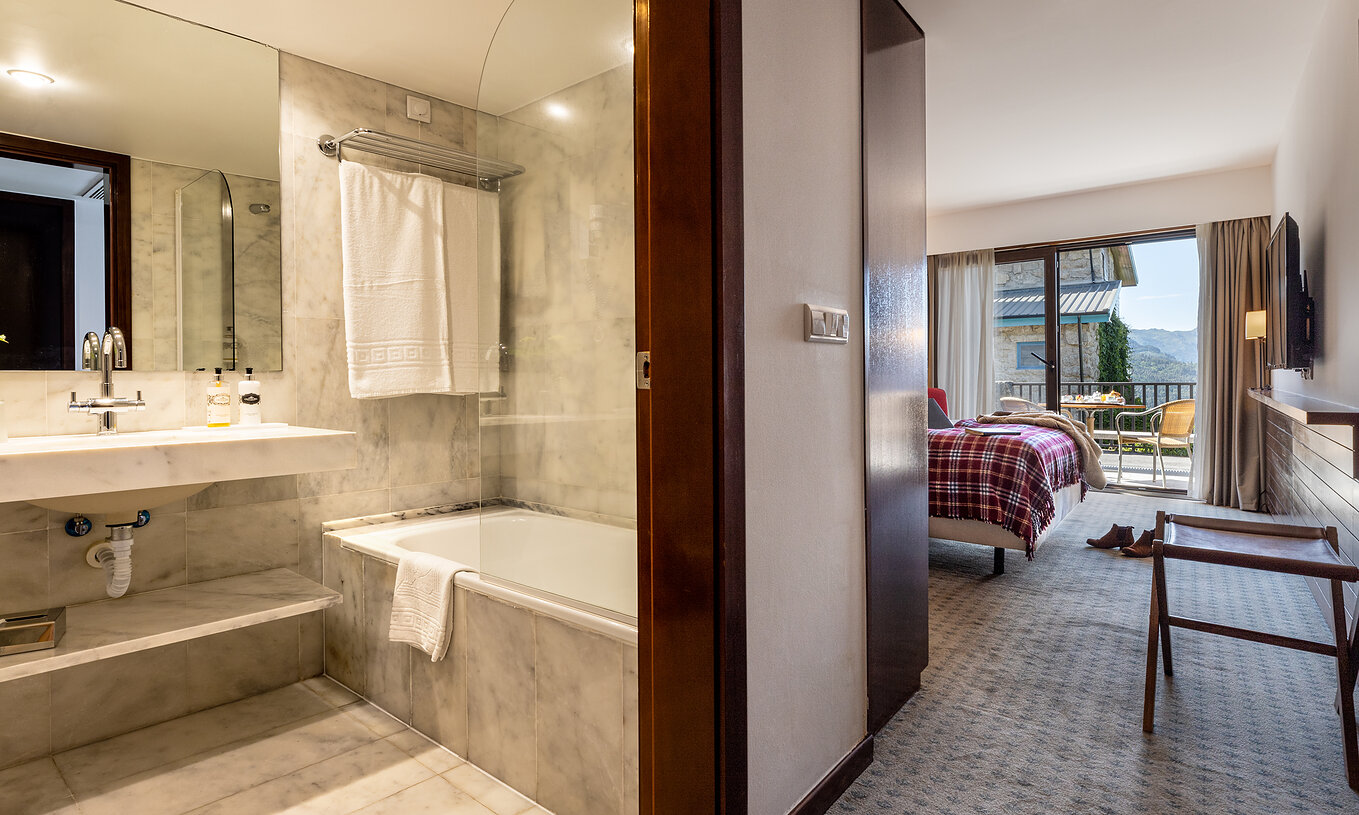 De Superior Terraskamer van Pousada Caniçada - Gerês heeft een badkamer met bad en wastafel en een kamer met balkon